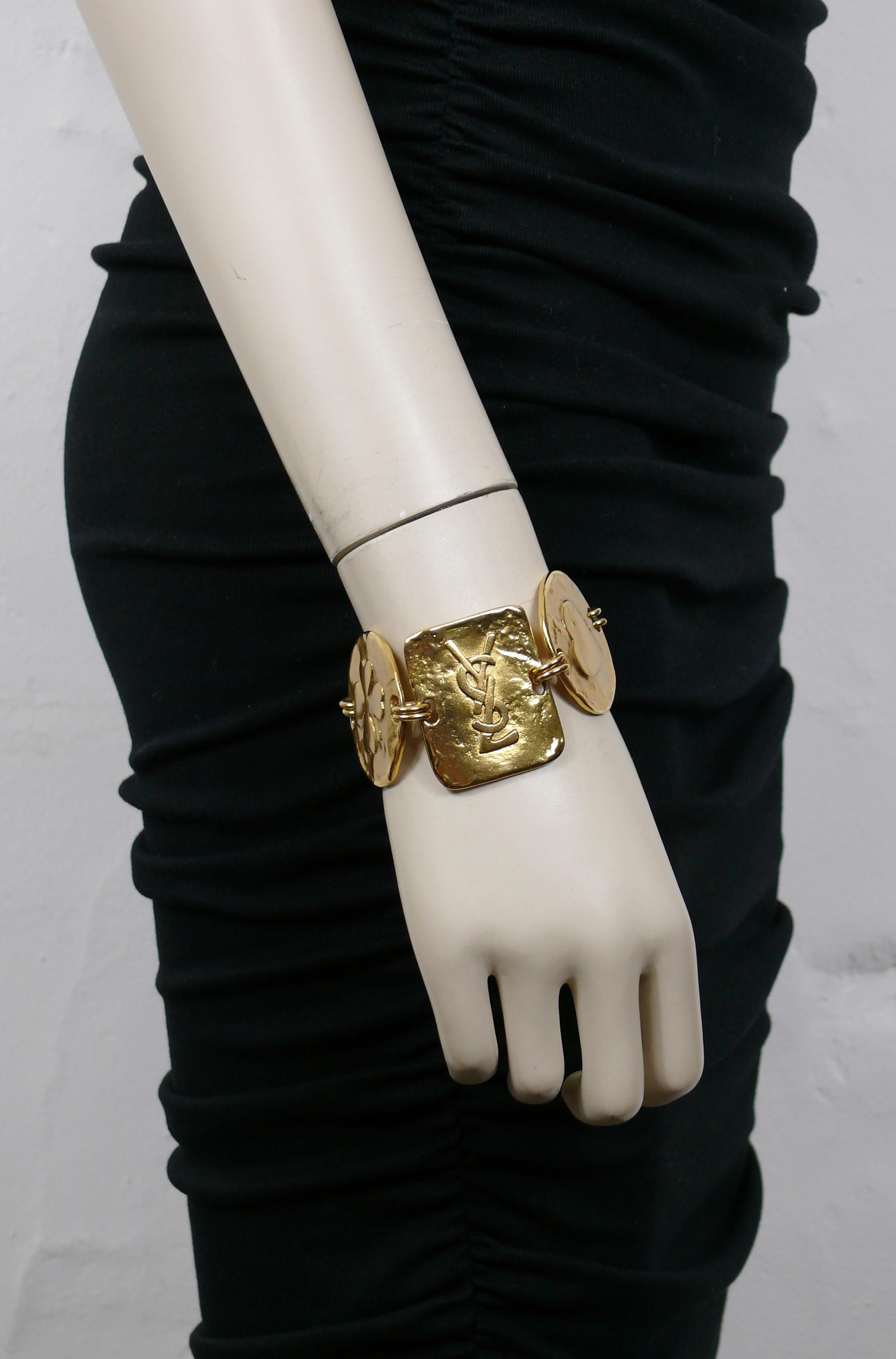 YVES SAINT LAURENT vintage gold tone link bracelet featuring iconic symbols : YSL logo, crescent moon, star, heart, lucky clover.

Push clasp closure.

Embossed with the YSL logo on the central link.
Embossed Made in France on the reverse