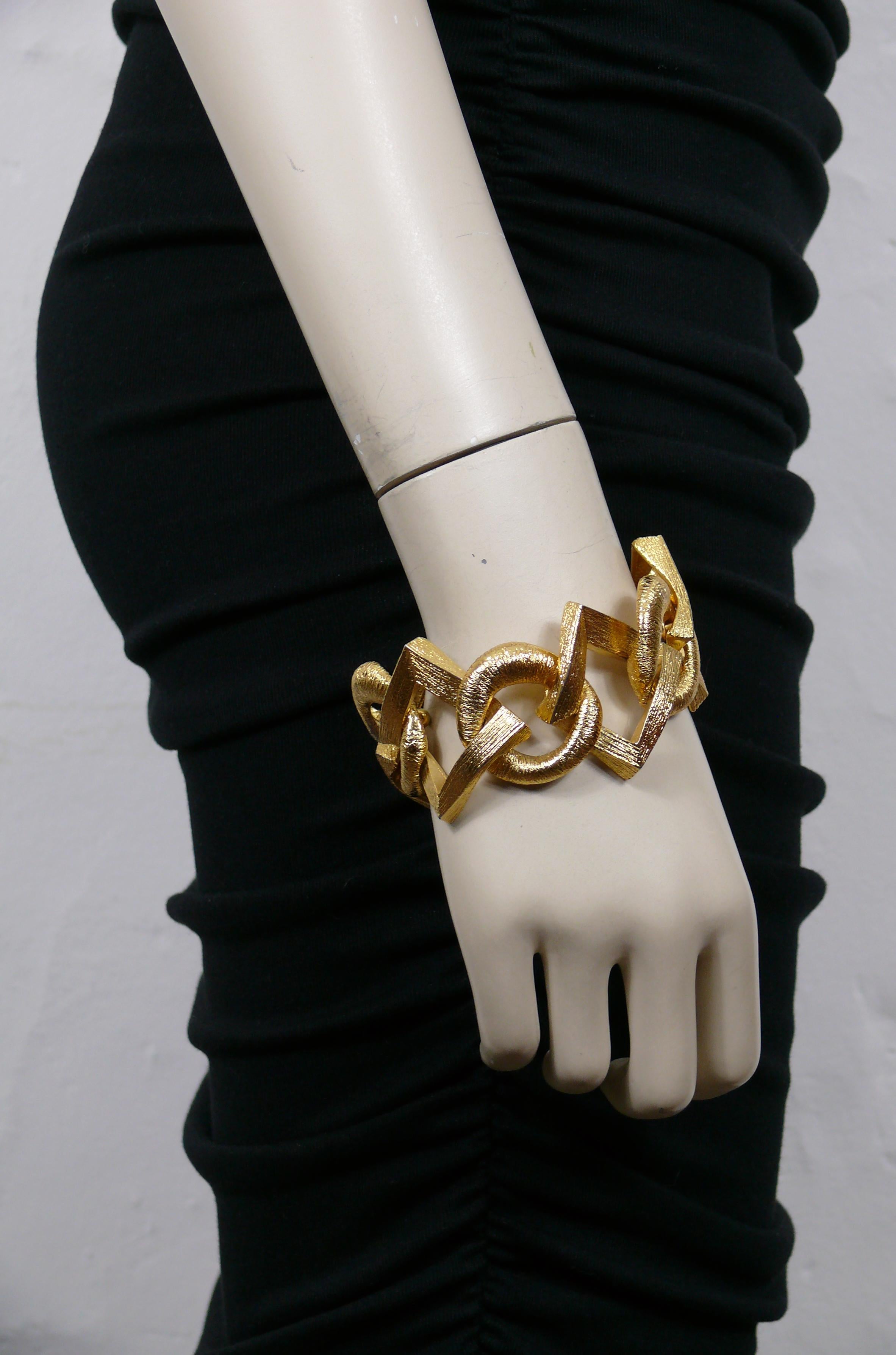 Bracelet vintage YVES SAINT LAURENT en métal doré avec des maillons texturés en forme d'ovale et de diamant.

Fermeture en T.

YSL en relief sur le T-bar.

Mesures indicatives : longueur env. 21 cm (8.27 inches) / largeur max. env. 4 cm (1.57