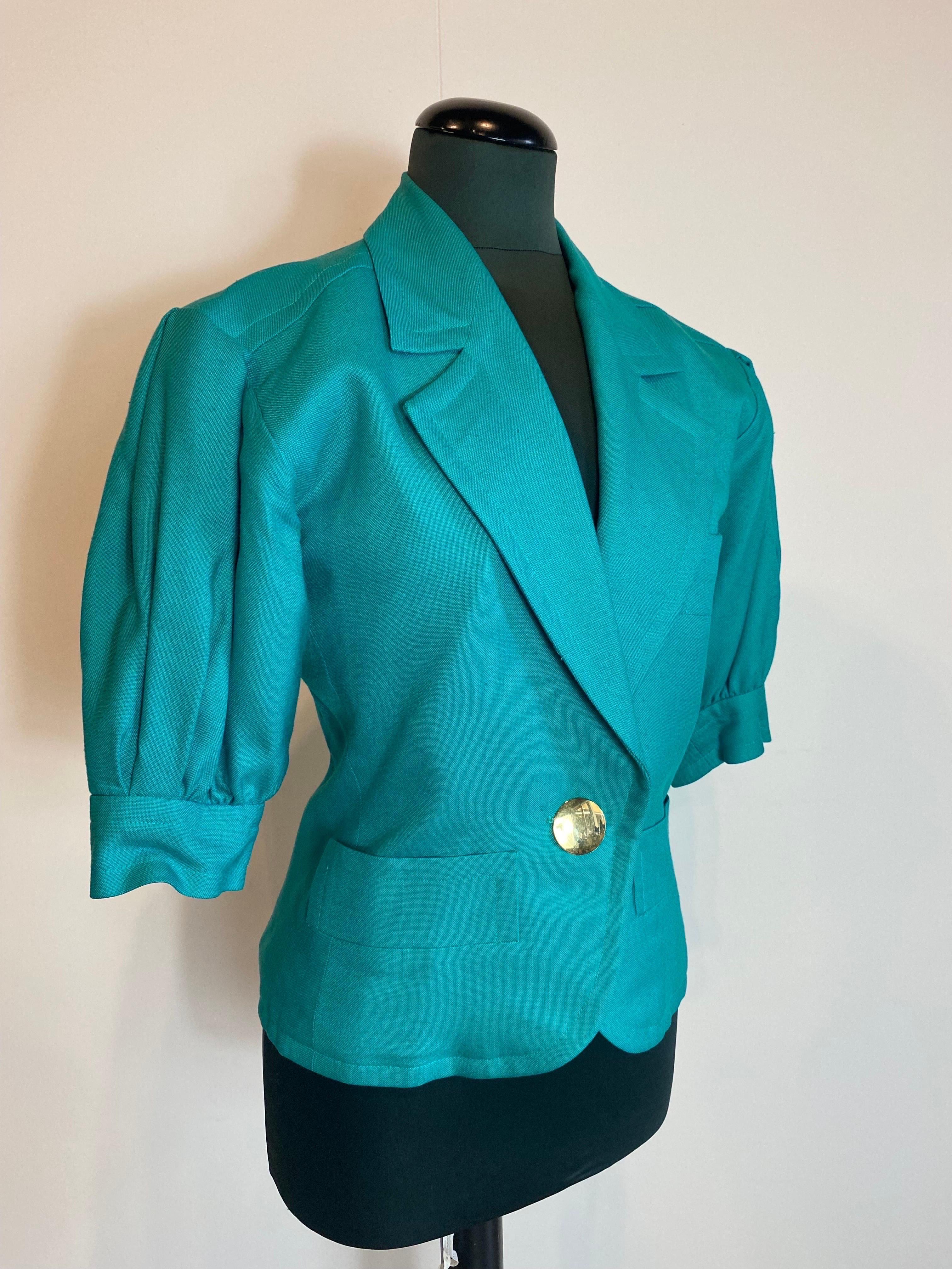 Veste verte Yves Saint Laurent
Vintage. Avec un bouton doré au centre. 
Modèle à manches ballon. 
Taille 38 Français.
Manche 30
Épaule 47
Buste 42
Longueur 61
Doublé à l'intérieur. Le tissu n'est pas indiqué sur le Label mais on considère qu'il