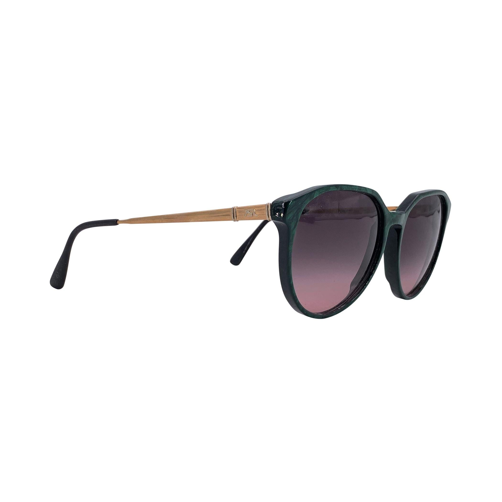 De la época dorada de la alta costura de los 80 nos llega una pieza tan enigmática como su nombre: estas gafas de sol Yves Saint Laurent Vintage Verde Perséfone son una verdadera encarnación de la feminidad audaz y el encanto atemporal. Fabricado en