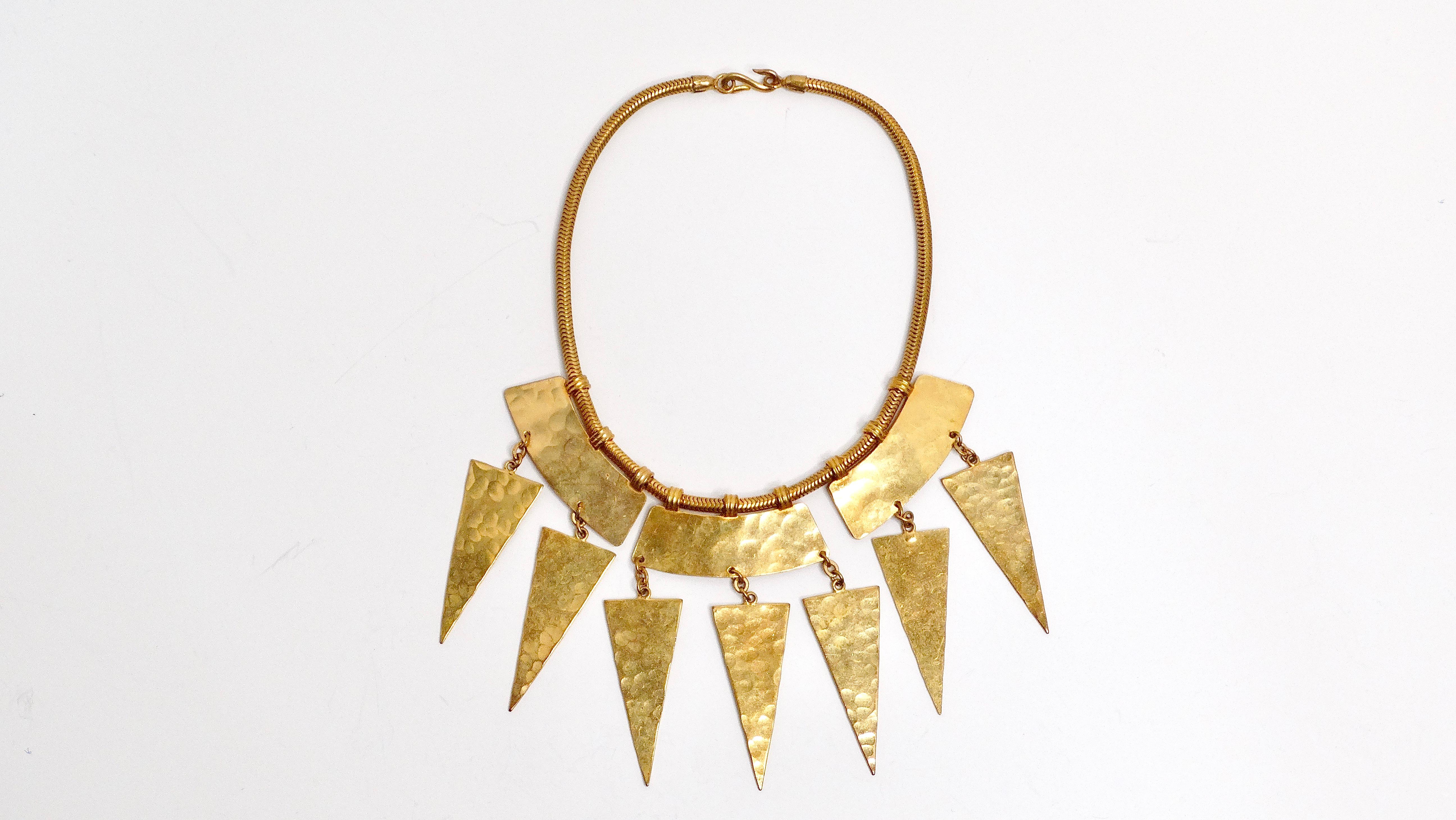 El Collar Vintage Yves Saint Laurent de Declaración Geométrica en Oro Martillado es una impresionante encarnación de la sofisticación audaz y el estilo atemporal. Fabricado en metal dorado, este collar tiene un llamativo acabado martillado que