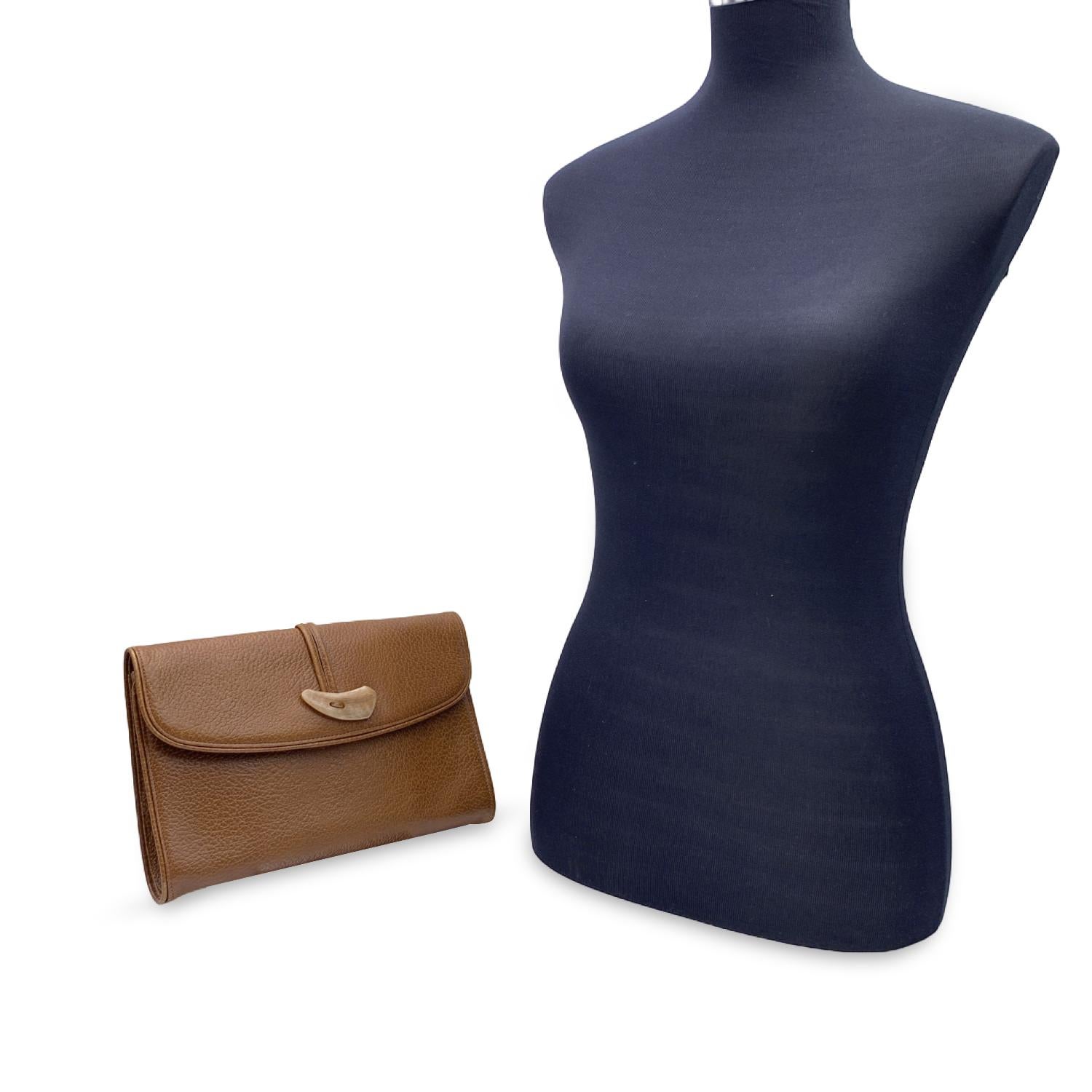 Yves Saint Laurent vintage clutch bag, crafted in light brown leather. It features a horn-shaped detail on the flap.Magnetic button closure.Fabric lining. 1 side zip pocket and 1 side open pocket inside. 'YVES SAINT LAURENT' tag
