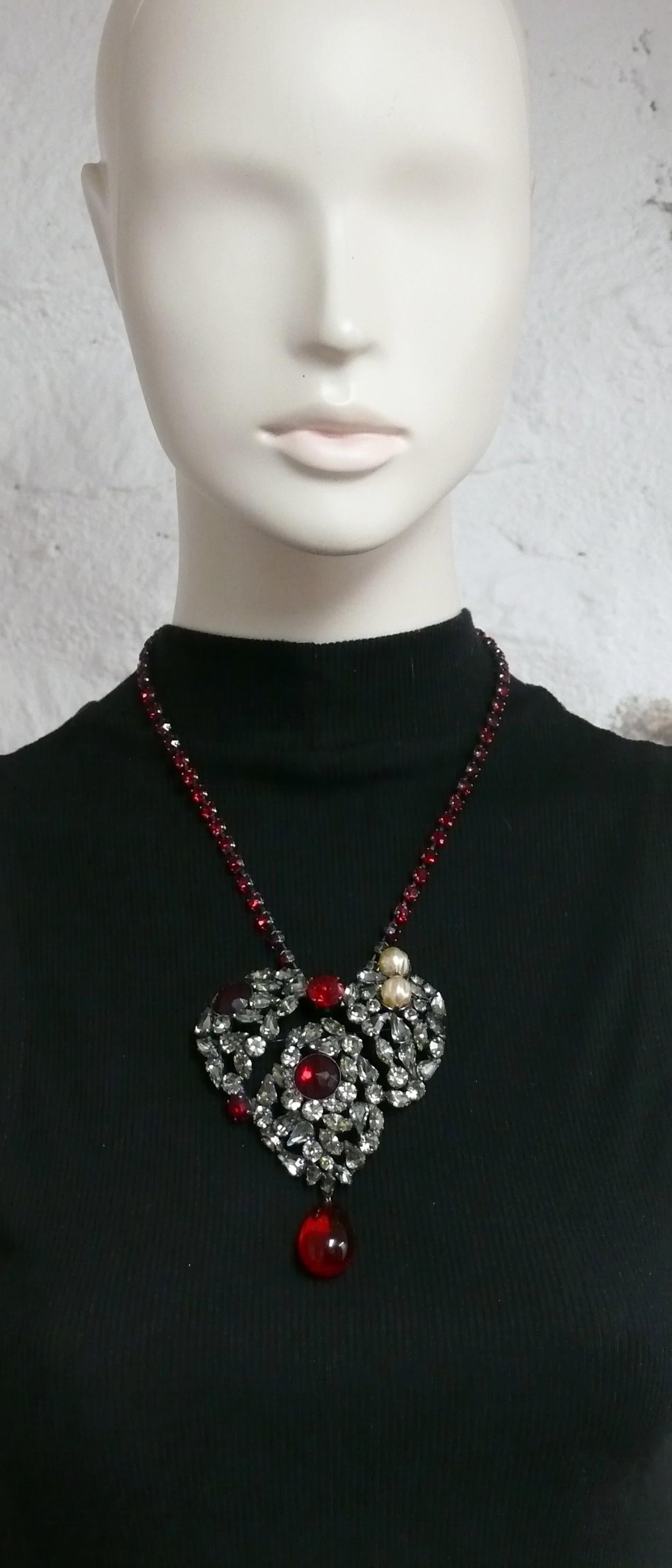 YVES SAINT LAURENT vintage massive iconic pendant necklace featuring a gun metal patina heart embellished with light grey and red crystals, faux pearls, red glass drop and a ruby rhinestone chain.

Similar model worn by LAETITIA CASTA on the catwalk