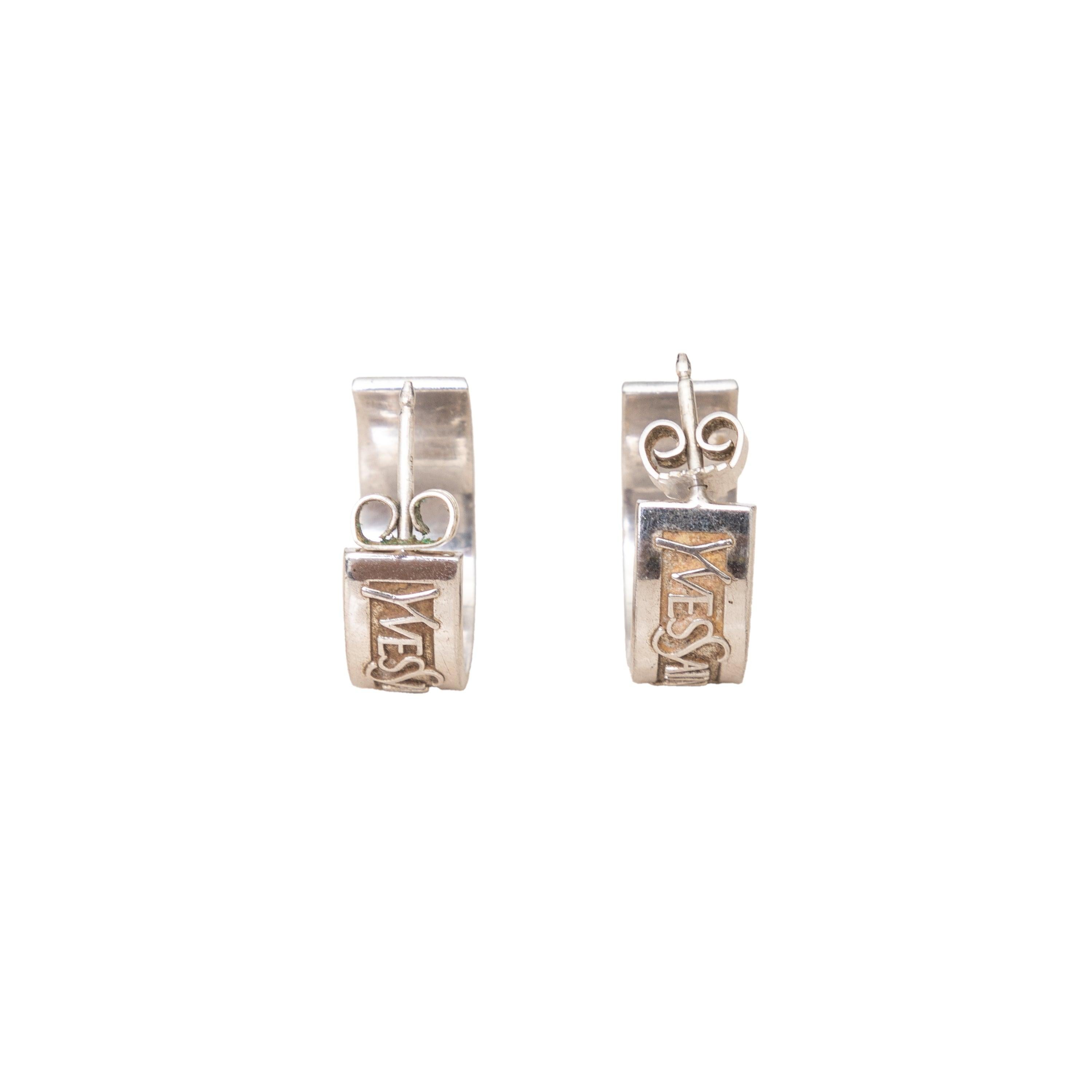 The Yves Saint Laurent Vintage Namesake Hoop Earrings are true vintage treasure from the 90s. Crafted from silver, these small hoop earrings feature an embedded logo and secure clutch back closures.
Remarks: There are some signs of wear. One of the