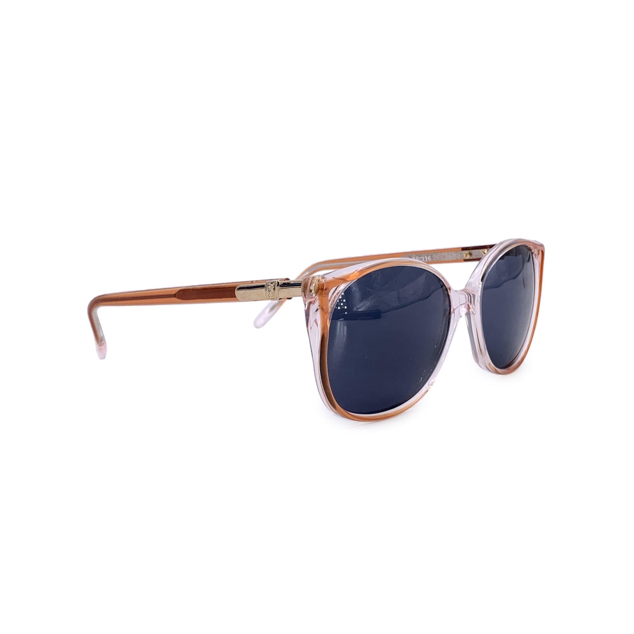 Adéntrate en la refinada elegancia de la alta costura de los años 80 con estas gafas de sol vintage Yves Saint Laurent, modelo Pomone - 612. Esta pieza, un diseño raro y original, presenta un marco clásico transparente bellamente acabado con