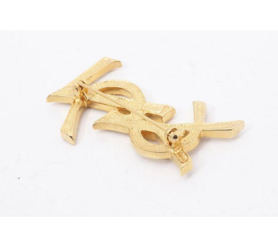 Yves Saint Laurent Vintage Pin Brooch features gold-tone hardware with YSL logo embellished with rhinestones, and a safety-pin closure clasp.
 

57852MSC