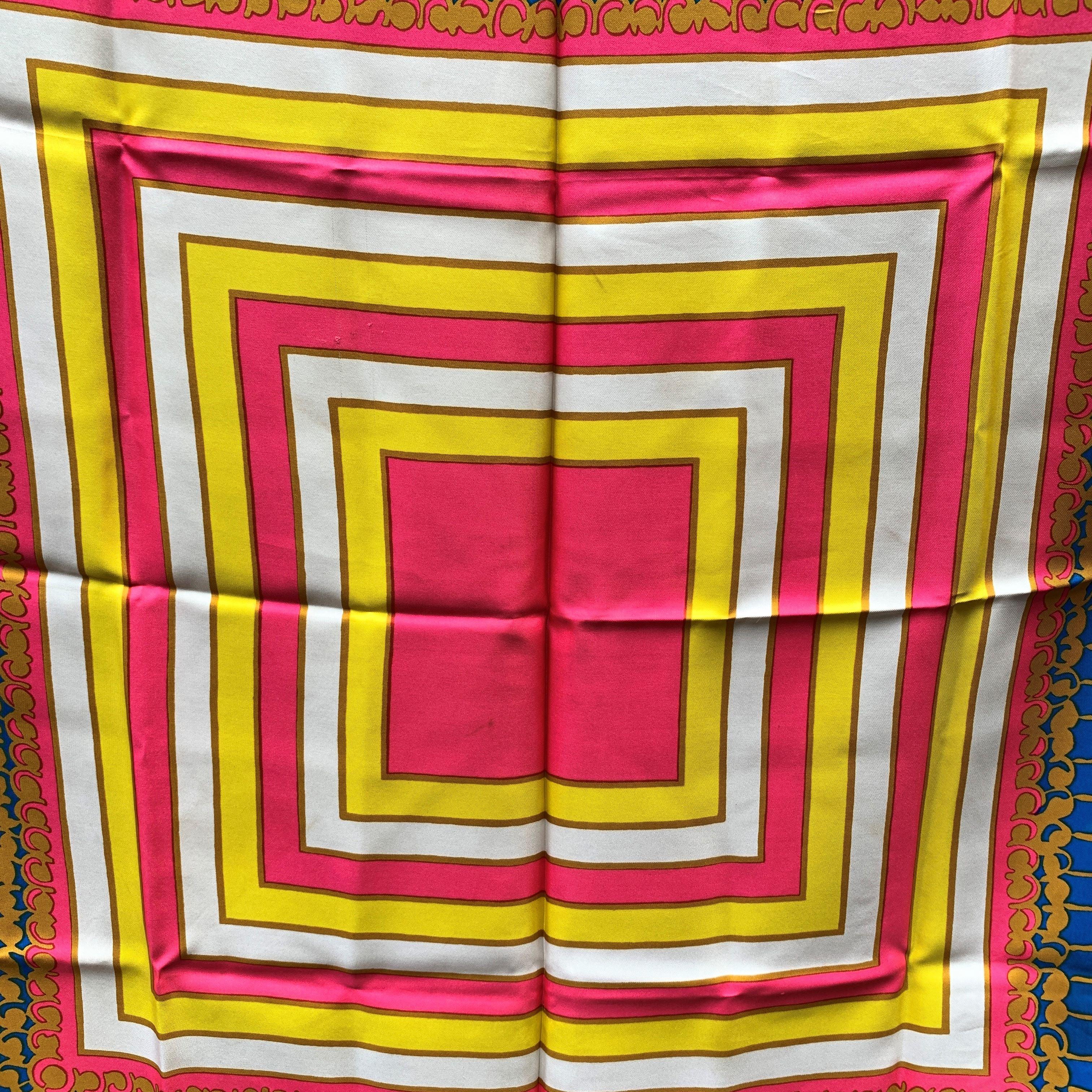 Vintage silk scarf by Yves Saint Laurent with multicolor design. Main colors are bright pink, yellow, blue, white. YVES SAINT LAURENT signature printed on the scarf. Approx. measurements: 33 x 33 inches - 83.8 x 83.8 cm Details MATERIAL: Silk COLOR: