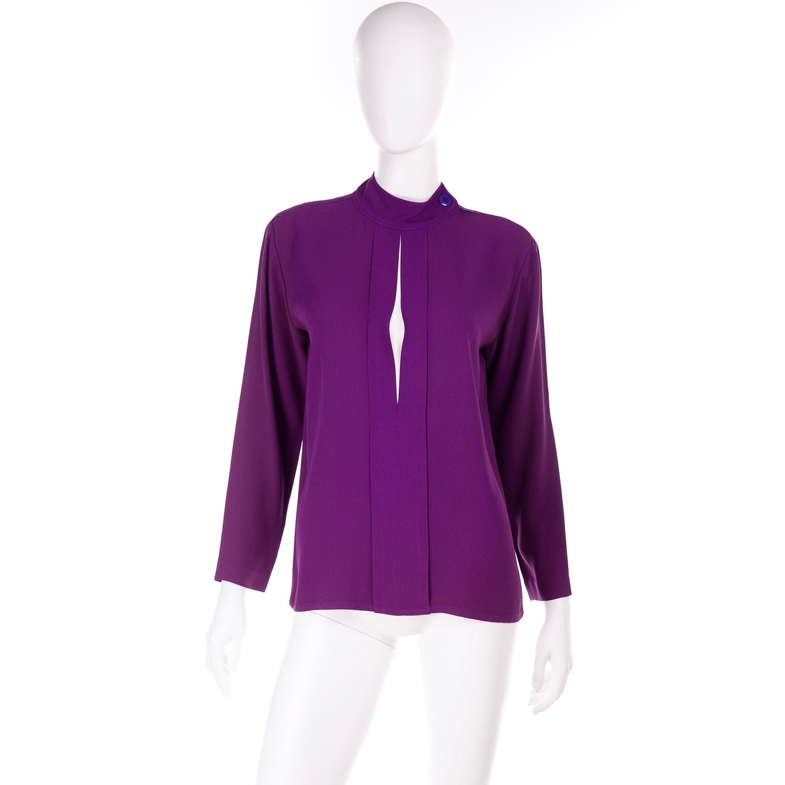 This vintage Yves Saint Laurent purple silk crepe top has a diamond cutout in the front with a buttoned high neck.  This long sleeve blouse was made in France and is labeled size 36. There is a metal zipper on the right shoulder with button at the
