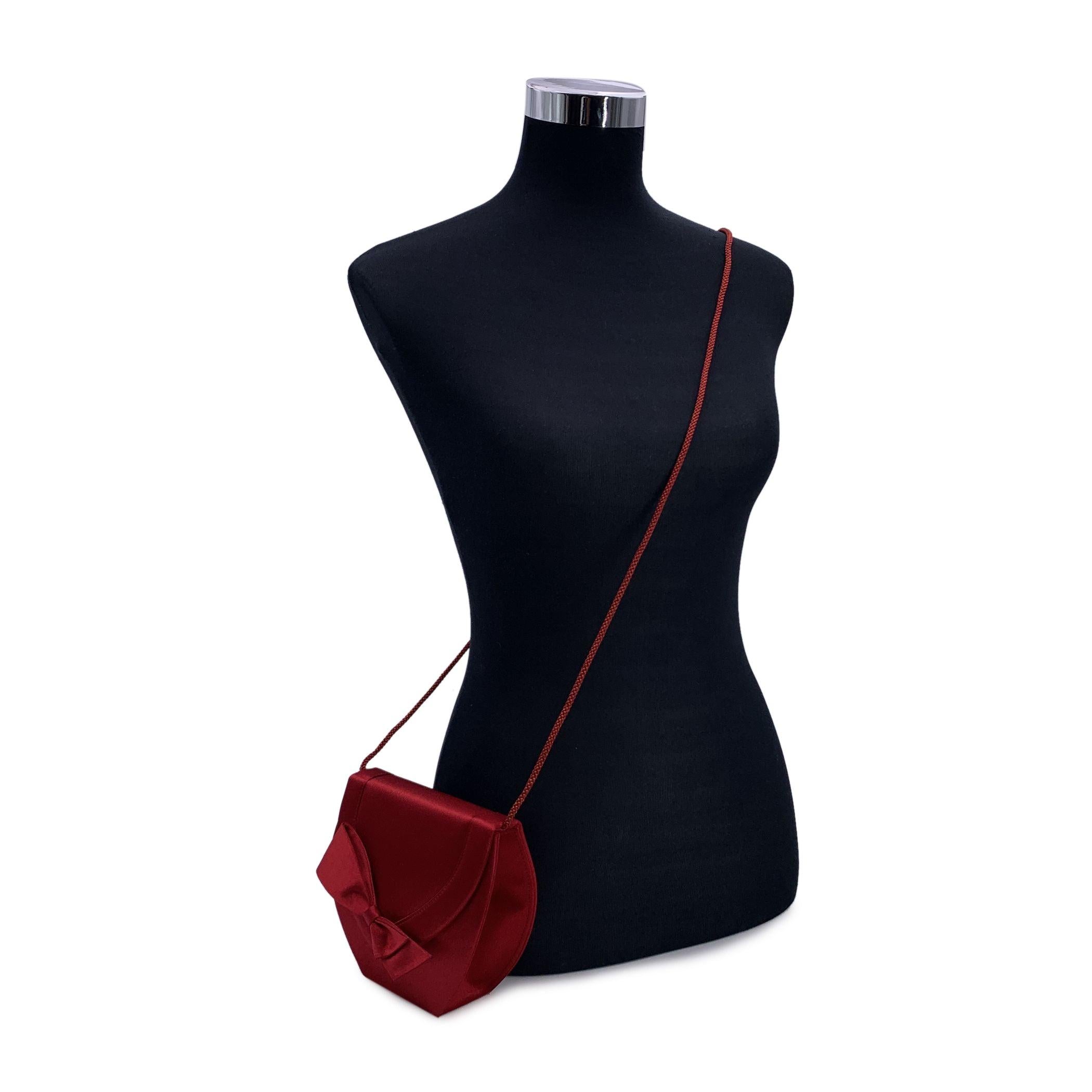Wunderschöne Vintage seltene kleine Schulter oder Crossbody Tasche von Yves Saint Laurent. Aus rotem Satin, geometrische Form, mit einer schönen roten Schleife auf der Vorderseite. Klappe mit Magnetknopfverschluss. Rotes Innenfutter aus Satin. 1
