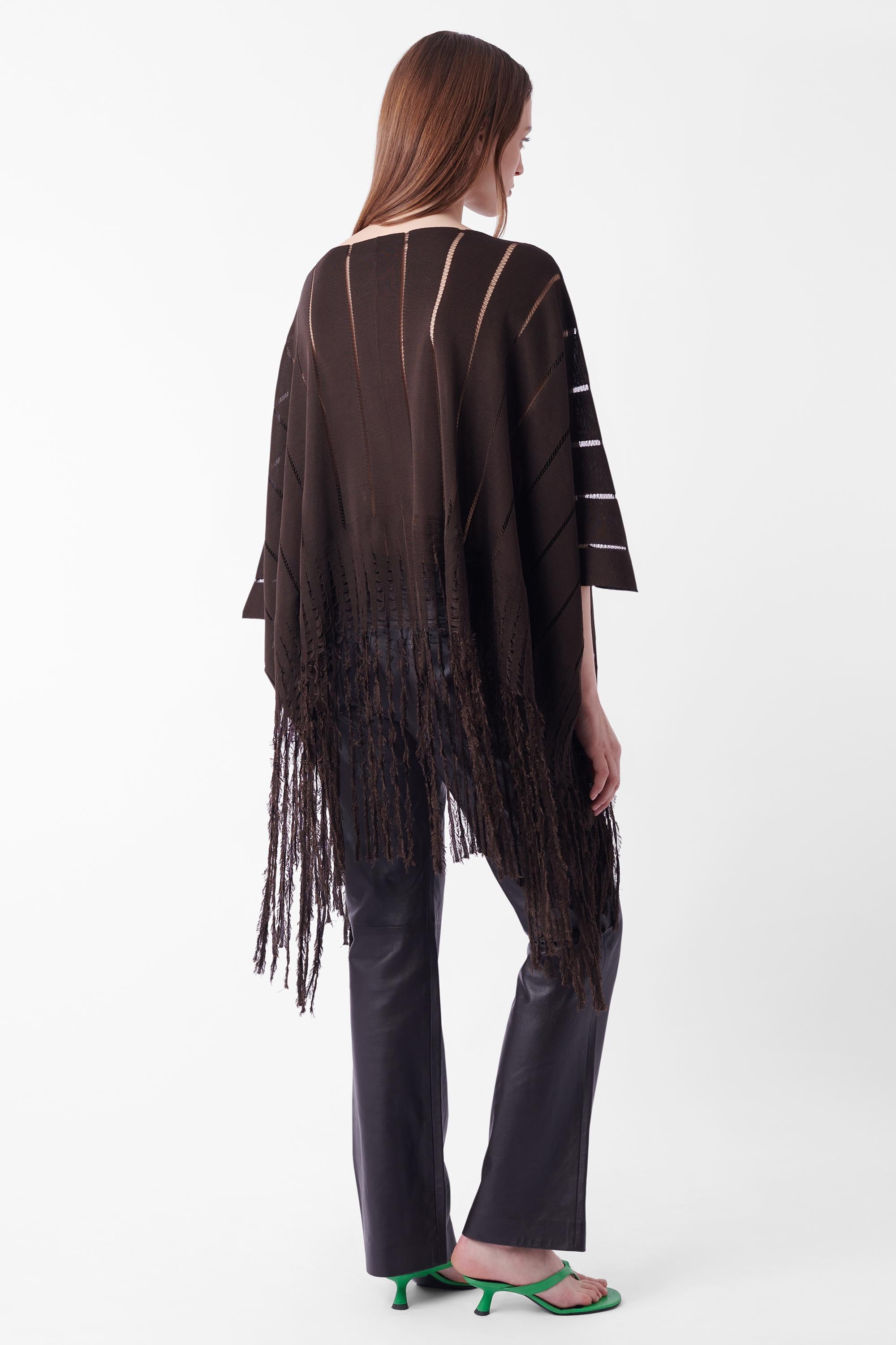 We are excited to present this Yves Saint Laurent by Tom Ford Spring Summer 2002 poncho. Features safari fringe running along the hem and sheer open stitch detailing running in a vertical format. Can be worn as a skirt. In great vintage condition,