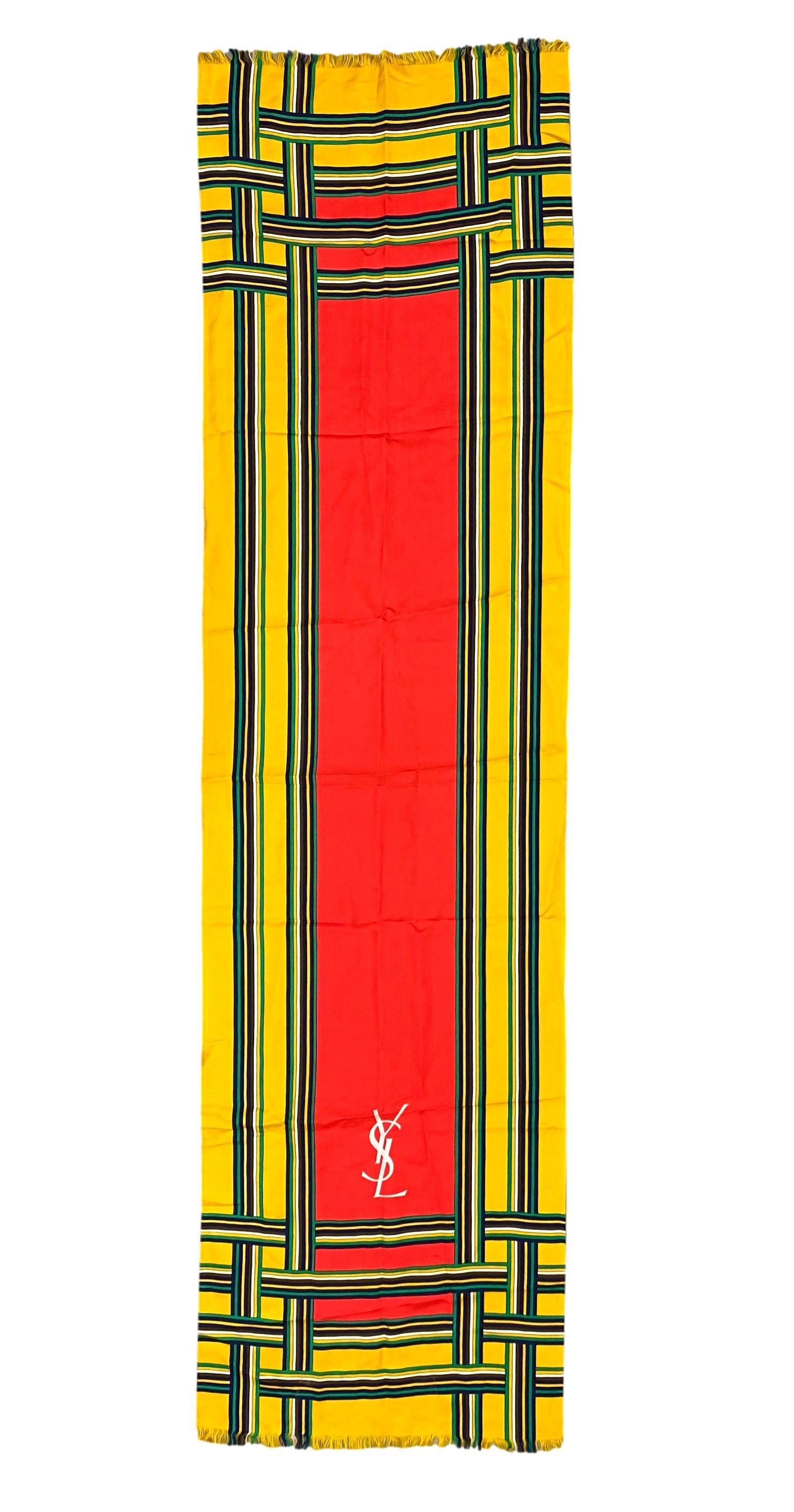 Echarpe longue en soie à carreaux multicolores Yves Saint Laurent, circa 1970 - 1975. Cette belle et classique écharpe à motif hachuré d'Yves Saint Laurent se présente dans une belle coloration jaune et rouge vif. Au début des années 1960, Yves