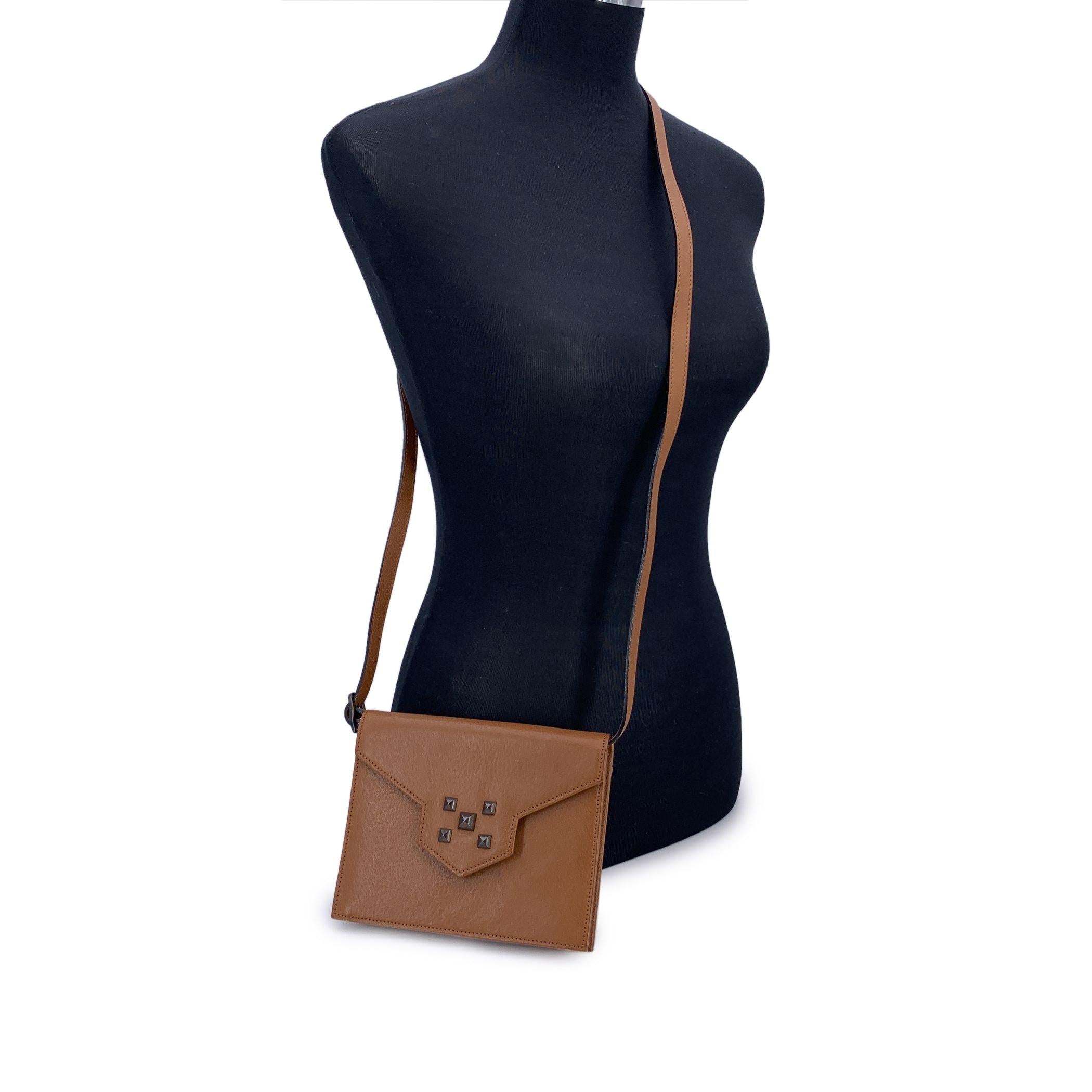 Diese Yves Saint Laurent Vintage Convertible Umhängetasche aus hellbraunem Leder besticht durch ihre Eleganz und ihr zeitloses Design mit einem Hauch von Rock-Chic-Flair. Die strukturierte Silhouette wird durch warmes, geschmeidiges Leder