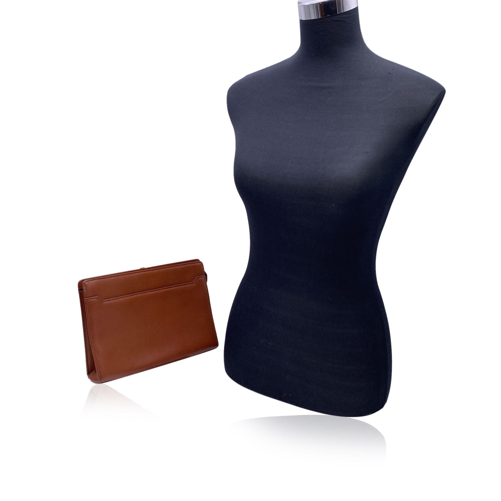 Yves Saint Laurent vintage clutch bag, crafted in tan leather. It features zip closure on top. YSL logo on the front. 1 open pocket on the front. Brown signature fabric lining. 1 side open pocket and 3 pen holder inside. 'YVES SAINT LAURENT'embossed