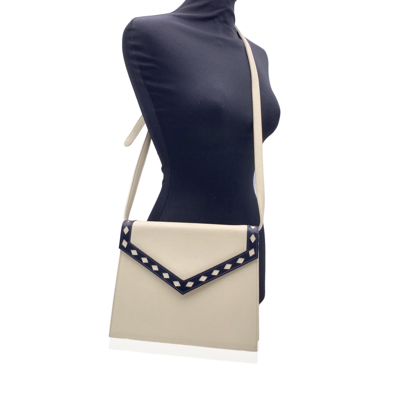 Vintage Yves Saint Laurent shoulder bag in white leather with navy blue leather trim. Flap with magnetic button closure. Adjustable and removable shoulder strap; convertible model, you can use it as a shoulder bag or you can use it as a clutch purse