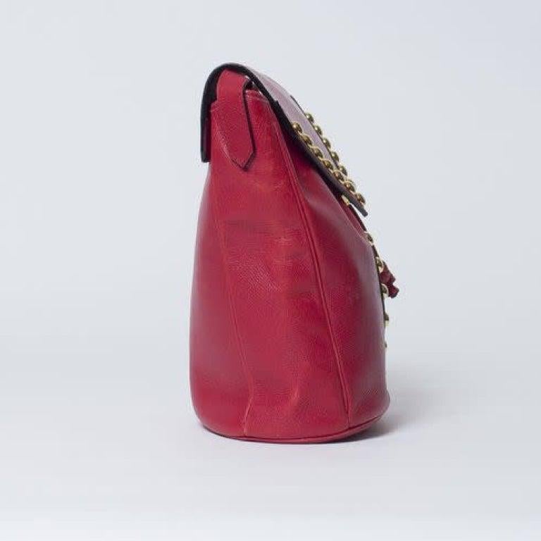 This vintage YSL bag is made with red leather with gold-tone studs at front forming the letter Y. Featuring drawstring closure, gold-toned hardware, black interior lining, and an interior zip pocket.

COLOR: Red
MATERIAL: Leather
ITEM CODE: Vintage