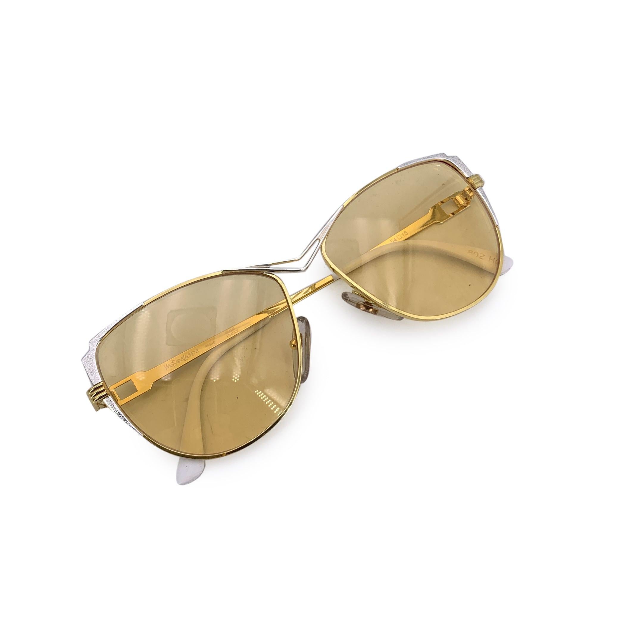 Dramatic and divine, these Yves Saint Laurent Vintage Purple and Gold Naxos Sunglasses are a dazzling embodiment of 1980s high fashion. Made in France from quality plastic, this rare cat-eye model captures the essence of YSL's fearless creativity