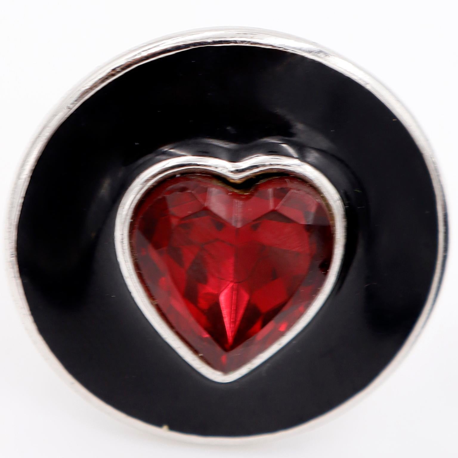 These beautiful vintage Yves Saint Laurent earrings feature YSL's signature hearts which were a familiar theme in a lot of his jewelry.. The clip earrings are on a silver plate base metal with black enamel and center red faceted heart shaped