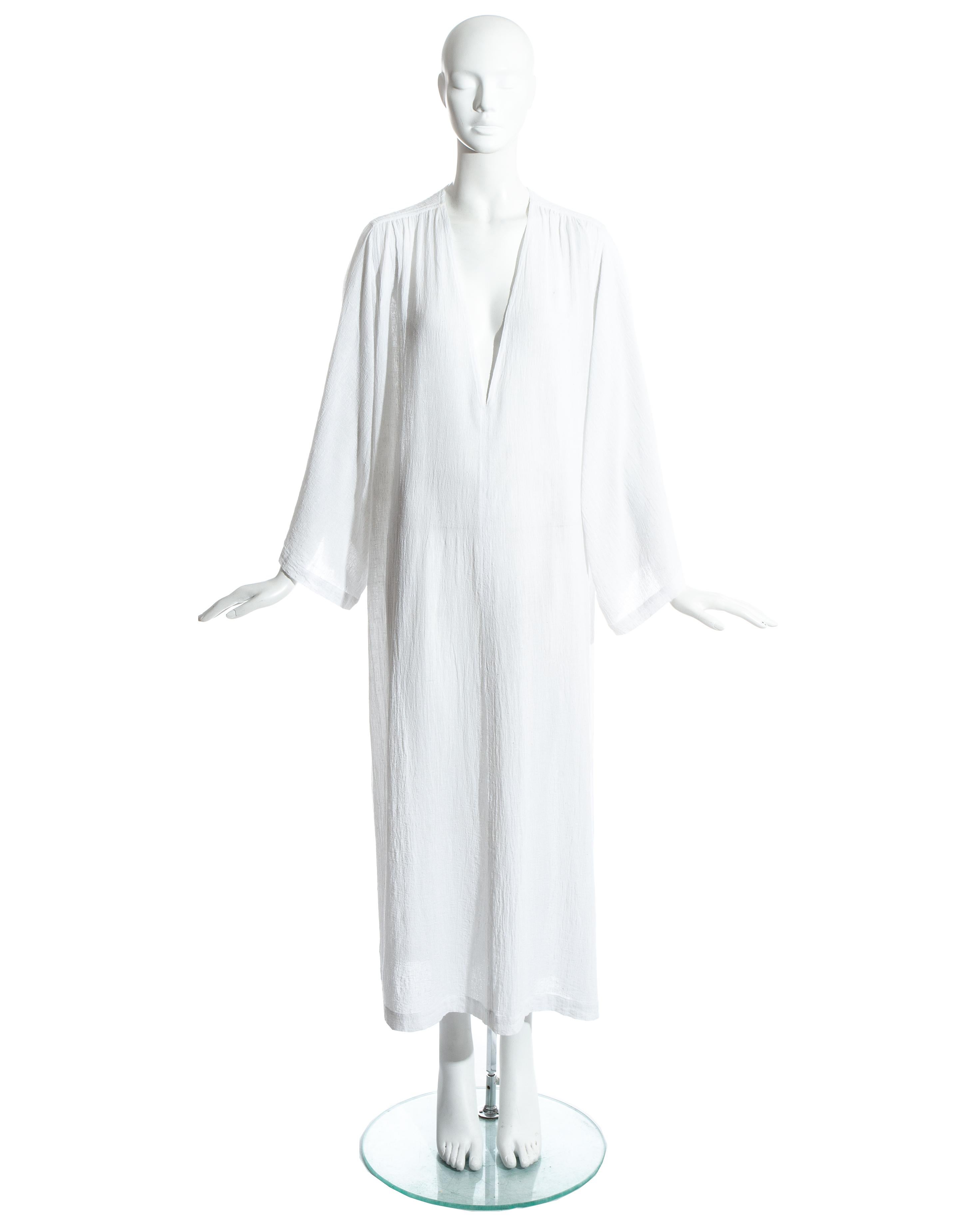 Yves Saint Laurent white cotton caftan. Wide sleeves, side slits and deep v neckline.

c. 1970s