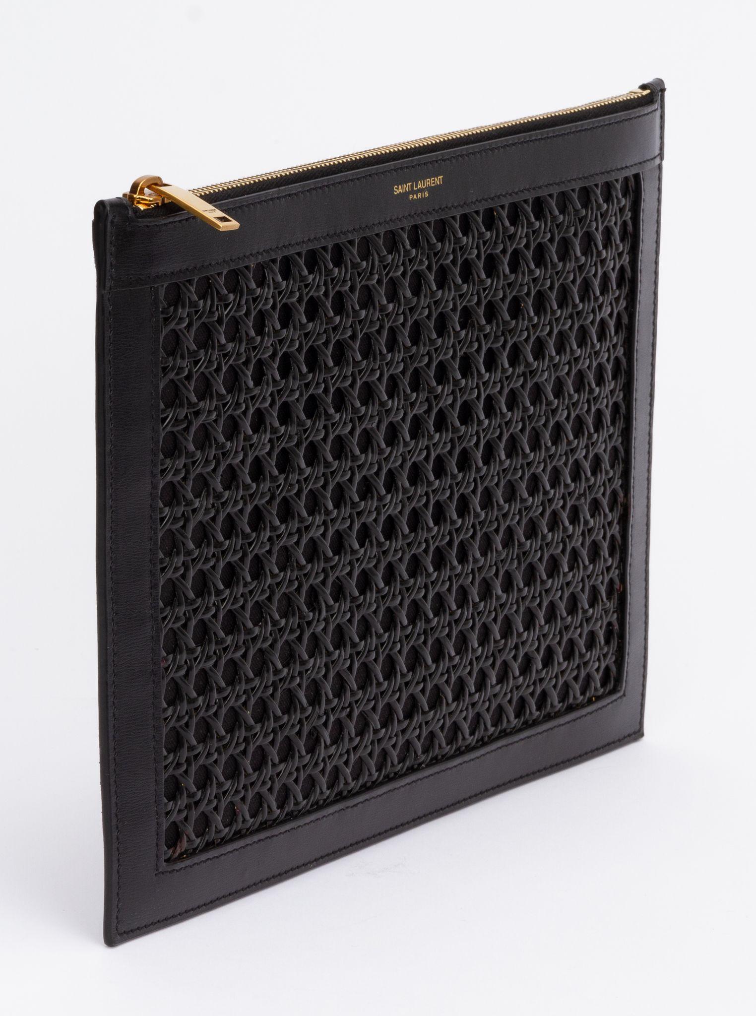 Yves Saint Laurent Clutch in Schwarz aus Weidengeflecht. Die Tasche ist mit poliertem Leder ausgestattet und hat einen Aufdruck des Saint Laurent Logos in Gold. Das Stück ist in ausgezeichnetem Zustand und wird mit der originalen Schutzhülle