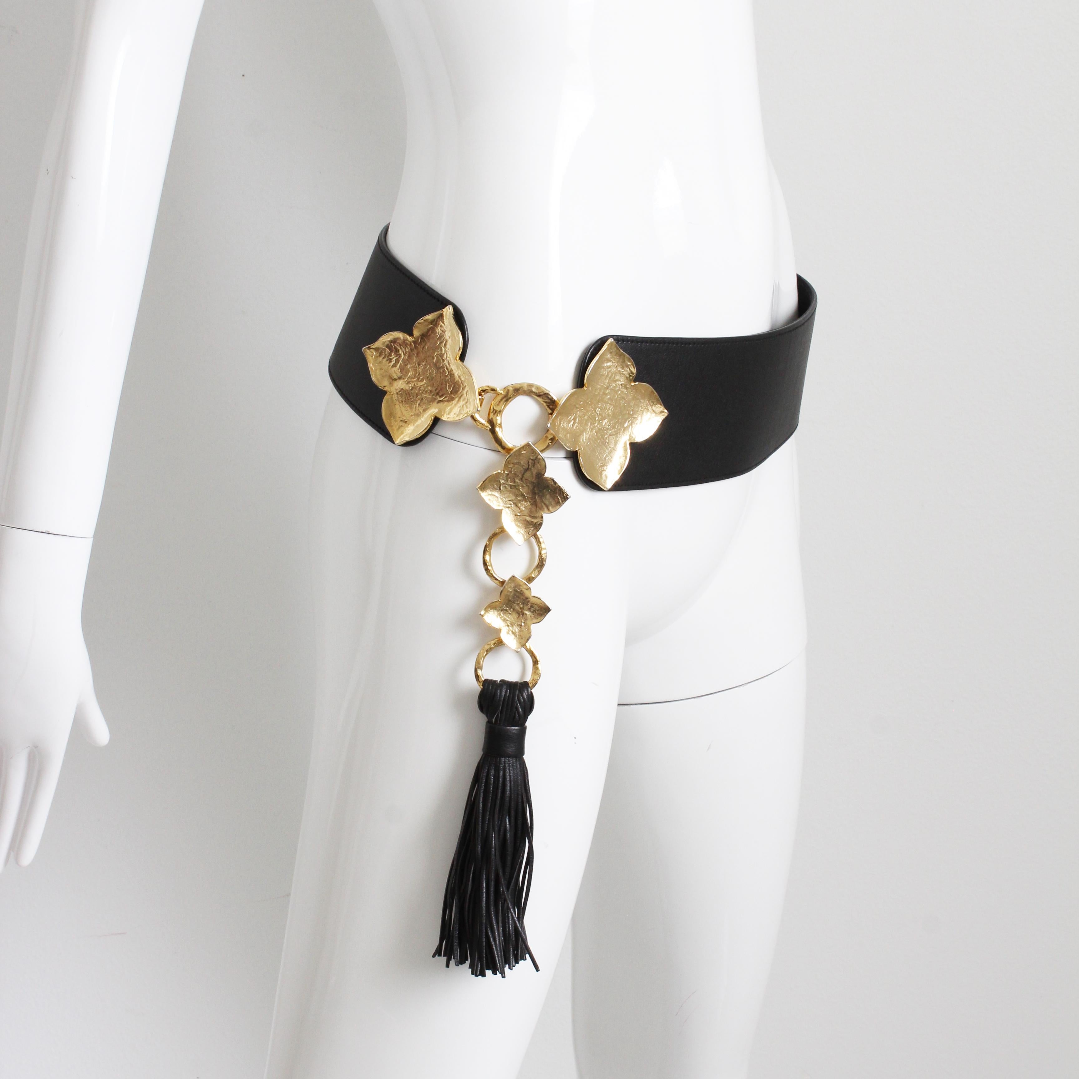Preowned Yves Saint Laurent wide belt with oversized abstract gold leaf buckle and tassel, likely made in the 2000s.  Most definitely a statement piece! Made from a wide black leather strap that measures 3in H, the gold leaf buckle and leather