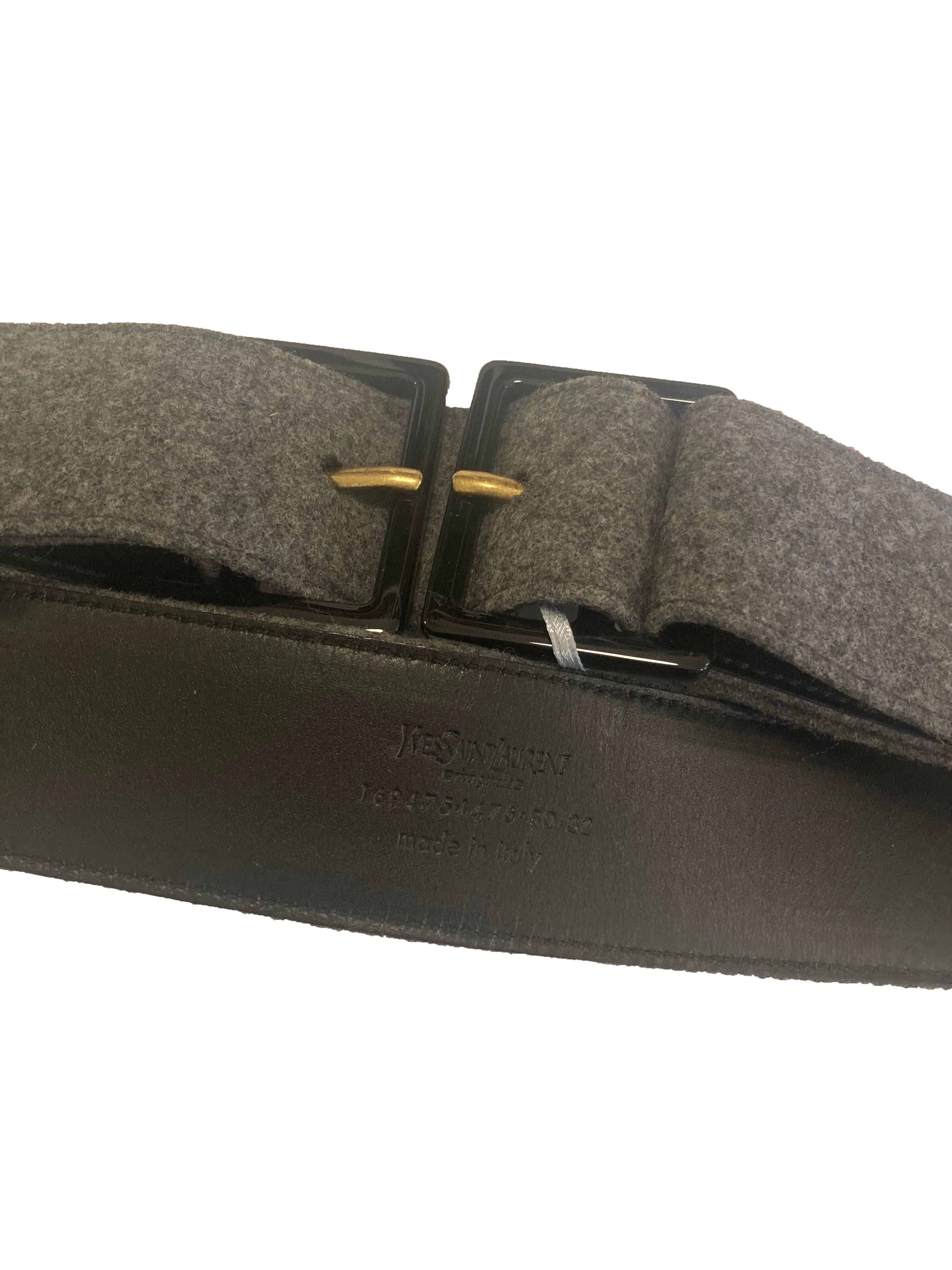 Cintura in lana grigia di Yves Saint Laurent. Con doppia fibbia in acetato nero e finiture in tonalità ottone. Prodotto in Italia. Numero di serie: 169475-1476-80-32. Dimensioni: 4,5 cm x 94 cm. Condizioni eccellenti, nessun segno sulla lana, un