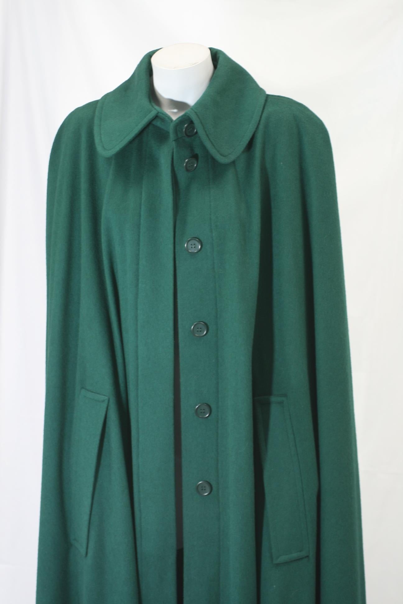 Yves Saint Laurent Wool Melton Cape in a wonderful evergreen wool. Full cut with dramatic huge sweep at hem. 1990's France. Covered button front, with slash access entry for hands. A forever classic. 
Excellent condition. 100% Wool Medium Weight