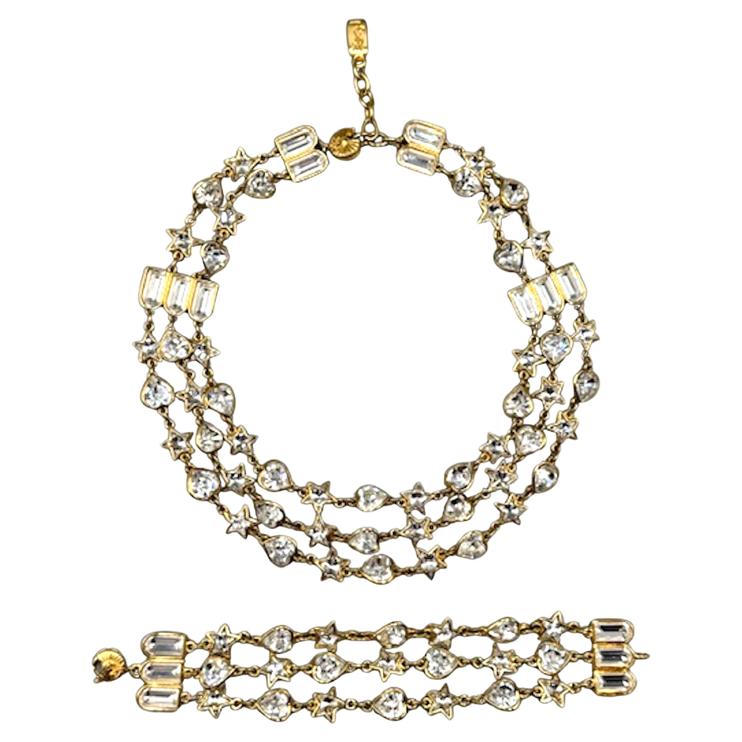 A remarkable and elegant Yves Saint Laurent necklace and bracelet set from the 1980s. Each piece has three strands of heart and star shape rhinestones links in gold plate. The necklace may be worn from 17.5 to 19.5 inches and has a width of about