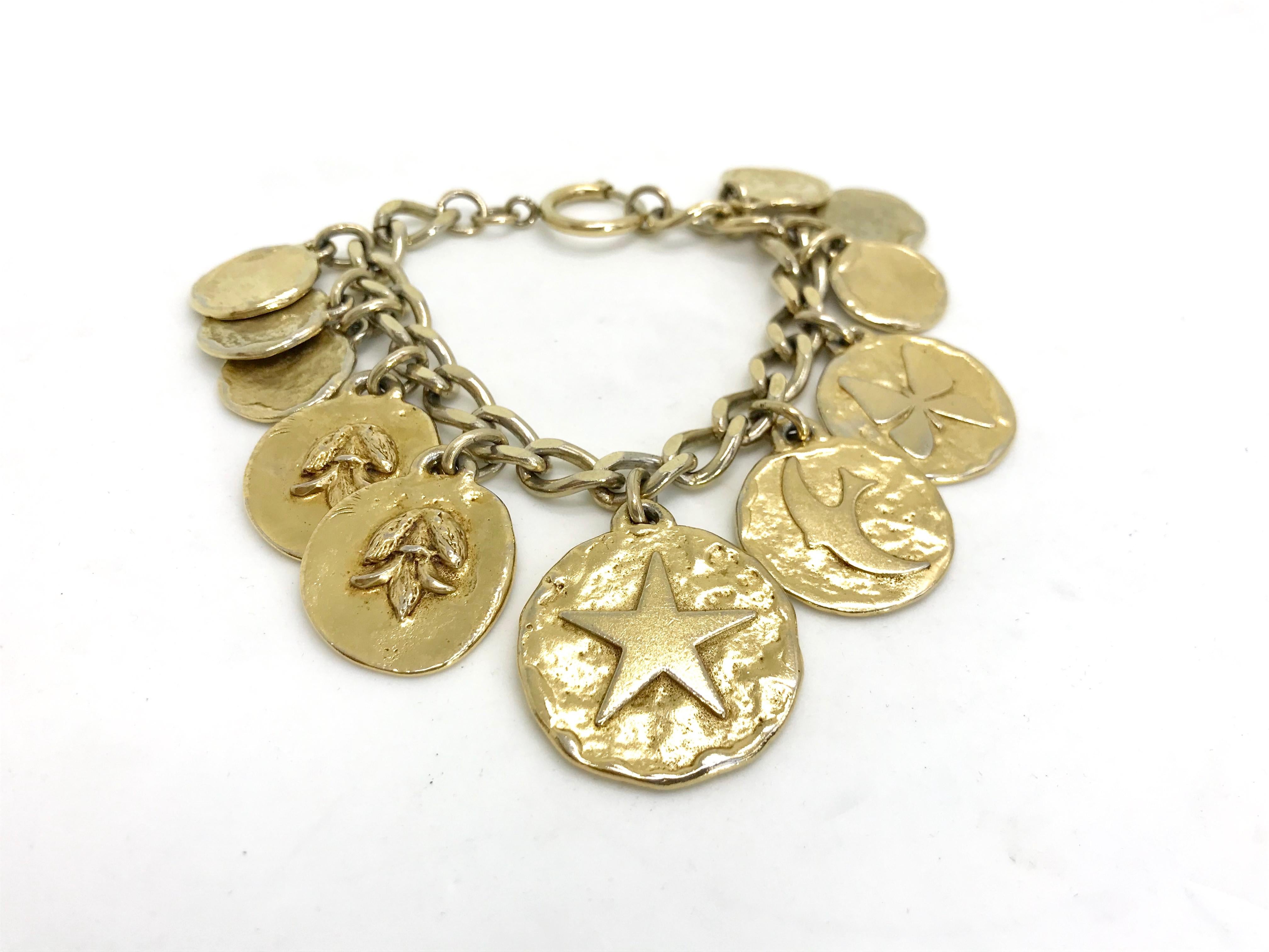 Iconic Yves Saint Laurent  / YSL 1980s Vintage Charm Bracelet.  Featuring a curb chain embellished with classic charms.  

A real statement piece for the discerning collector.

Length : 7,5 inches
- Charm diameter ( biggest ) : 1,2 inch 
- Weight :