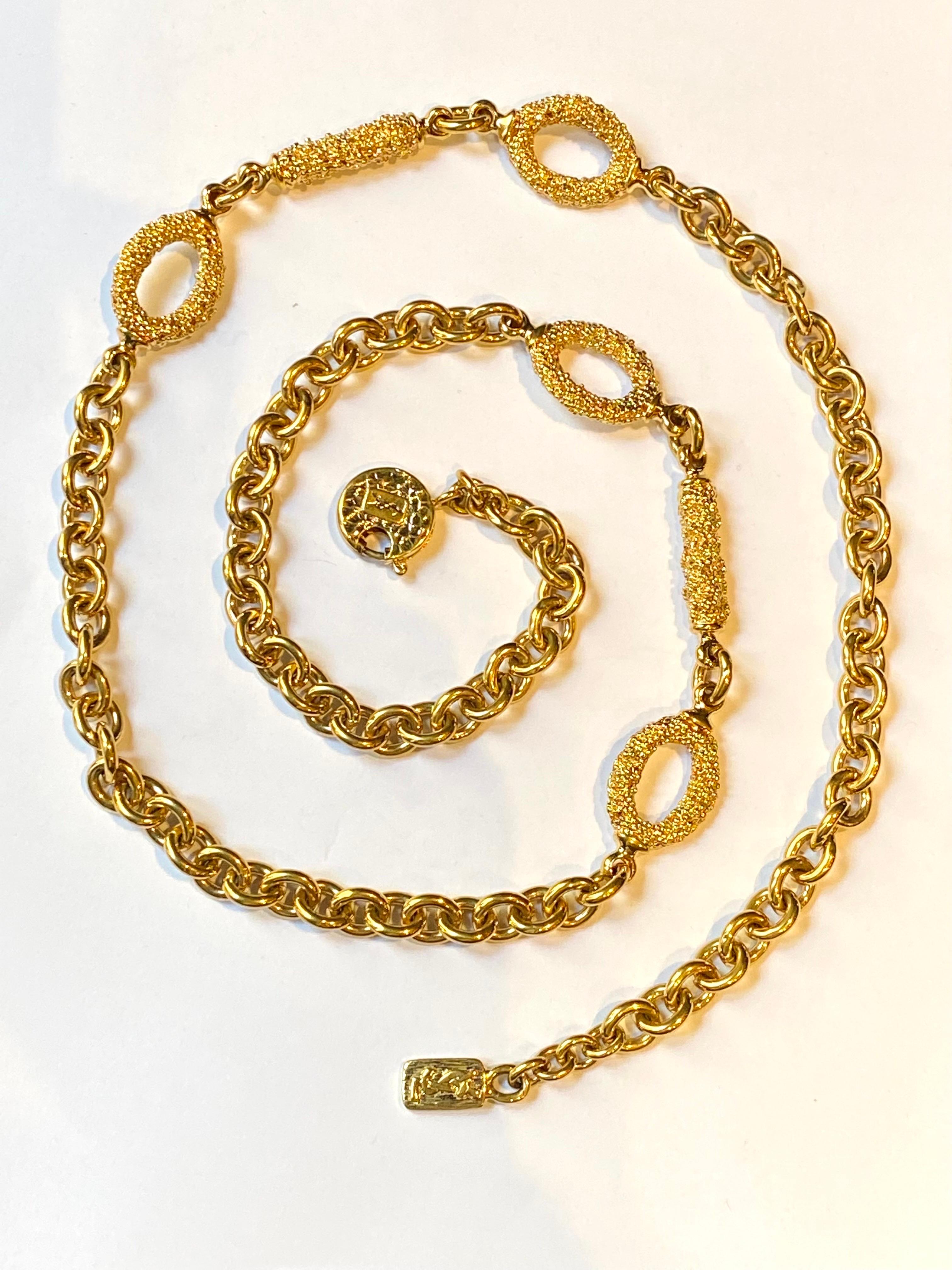 Presented is an elegant 1980s Yves Saint Laurent 35 inch long necklace in 18K gold plate. The classic cable link chain of lightly oval round links is accented with two sets of ornamental links. Each set is comprised of two oval rings flanking a
