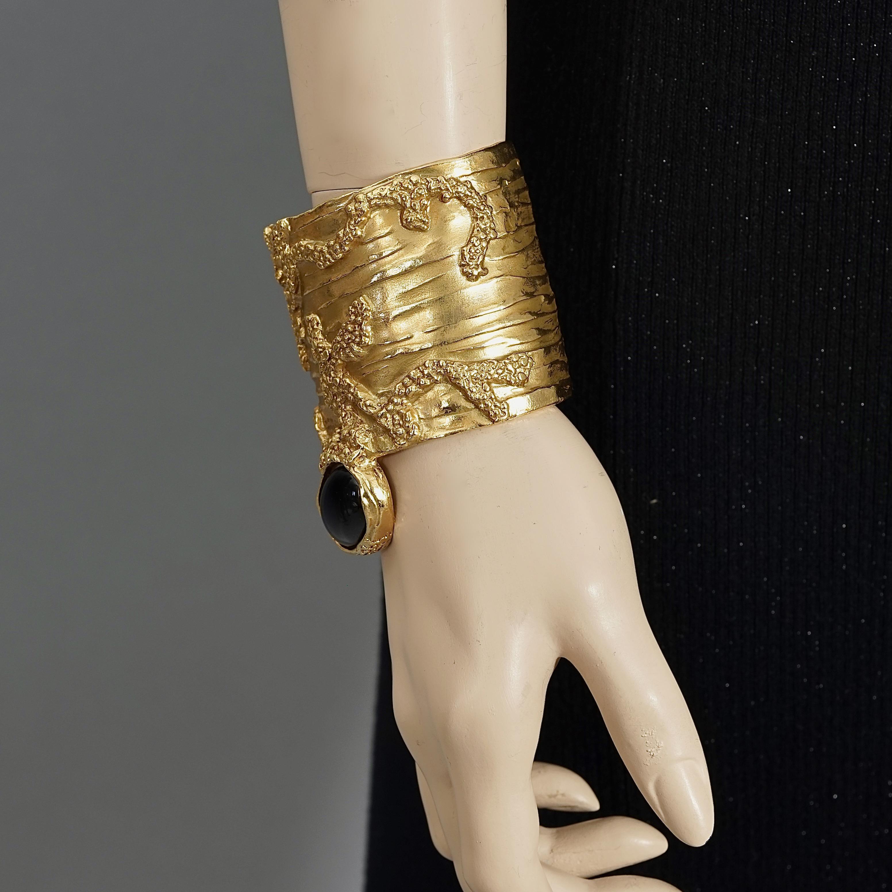 Yves Saint Laurent YSL Arty Black Cabochon Textured Wide Cuff Bracelet

Measurements:
Height: 3.15 inches (8 cm)
Inside Circumference: 6.89 inches (17.5 cm) 

Features:
- 100% Authentic YVES SAINT LAURENT from the Arty Collection.
- Wide textured