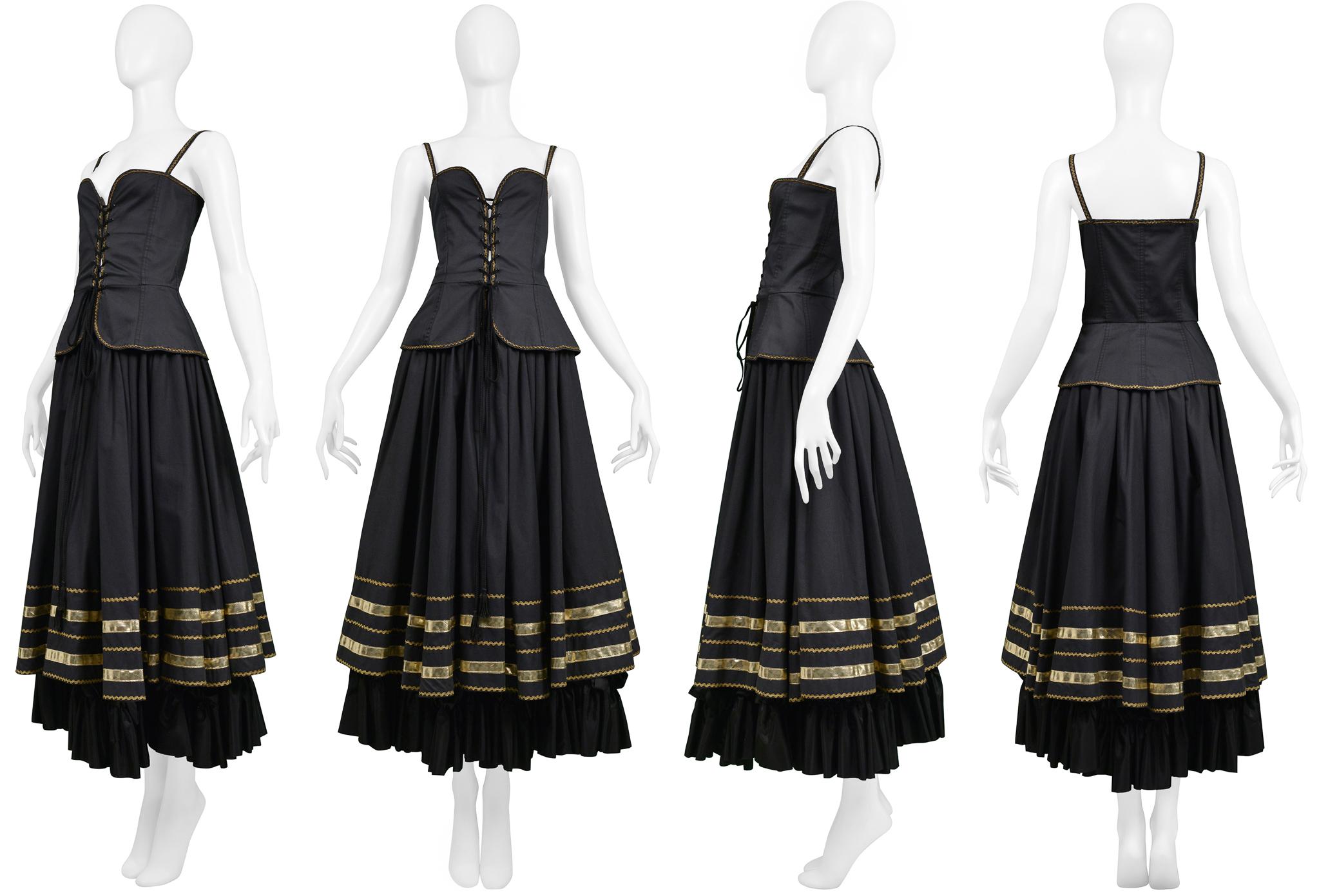 Resurrection Vintage est heureux de vous proposer un ensemble vintage Yves Saint Laurent noir et or composé d'un corset et d'une jupe paysanne. Le corset se caractérise par des lacets sur le devant, un corps ajusté et des bordures dorées. La jupe
