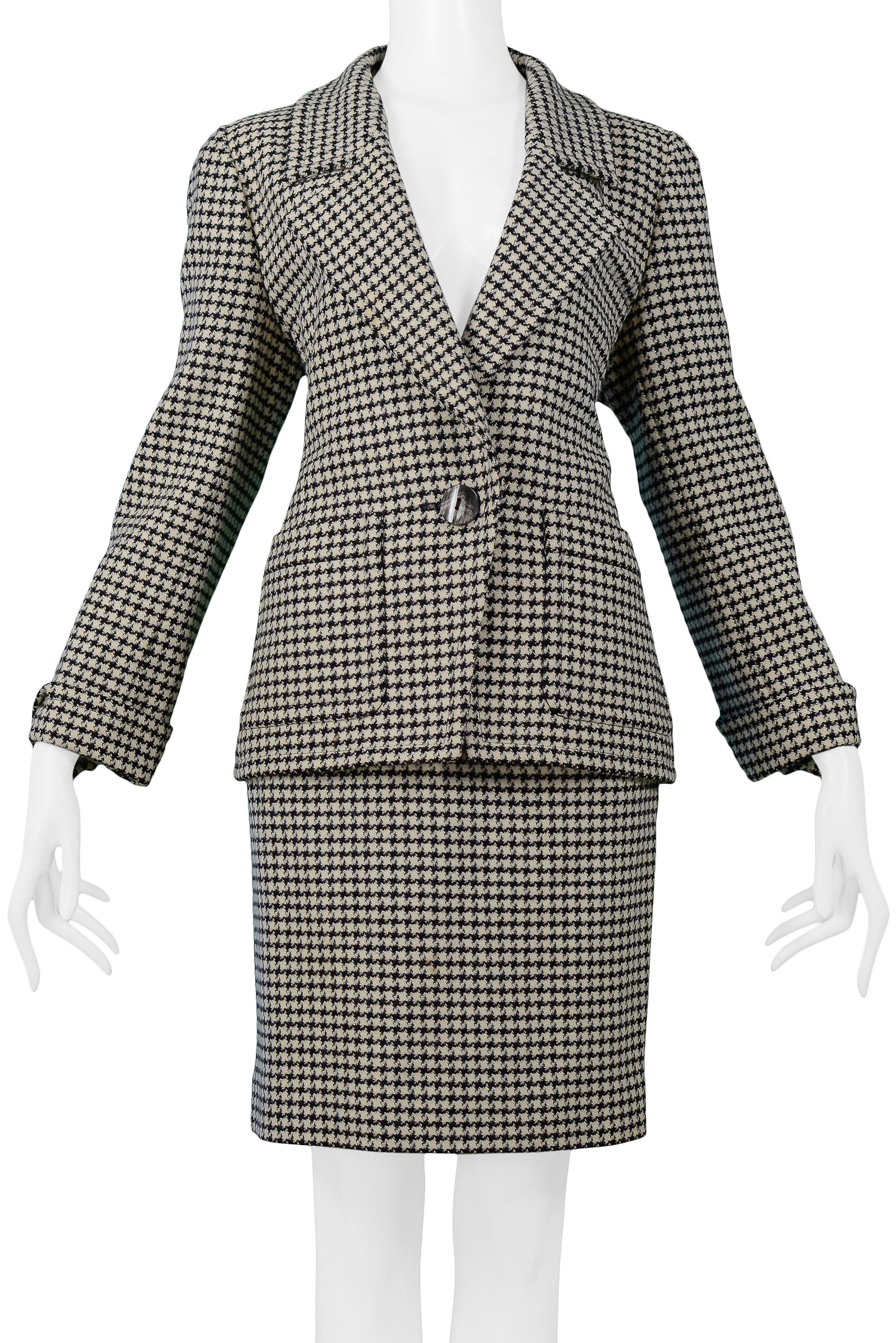 Resurrection Vintage è lieta di offrire un abito vintage con gonna a quadri in lana di Yves Saint Laurent, di colore nero, grigio e bianco sporco, caratterizzato da una giacca lunga fino ai fianchi con tasche applicate, chiusura a un bottone,