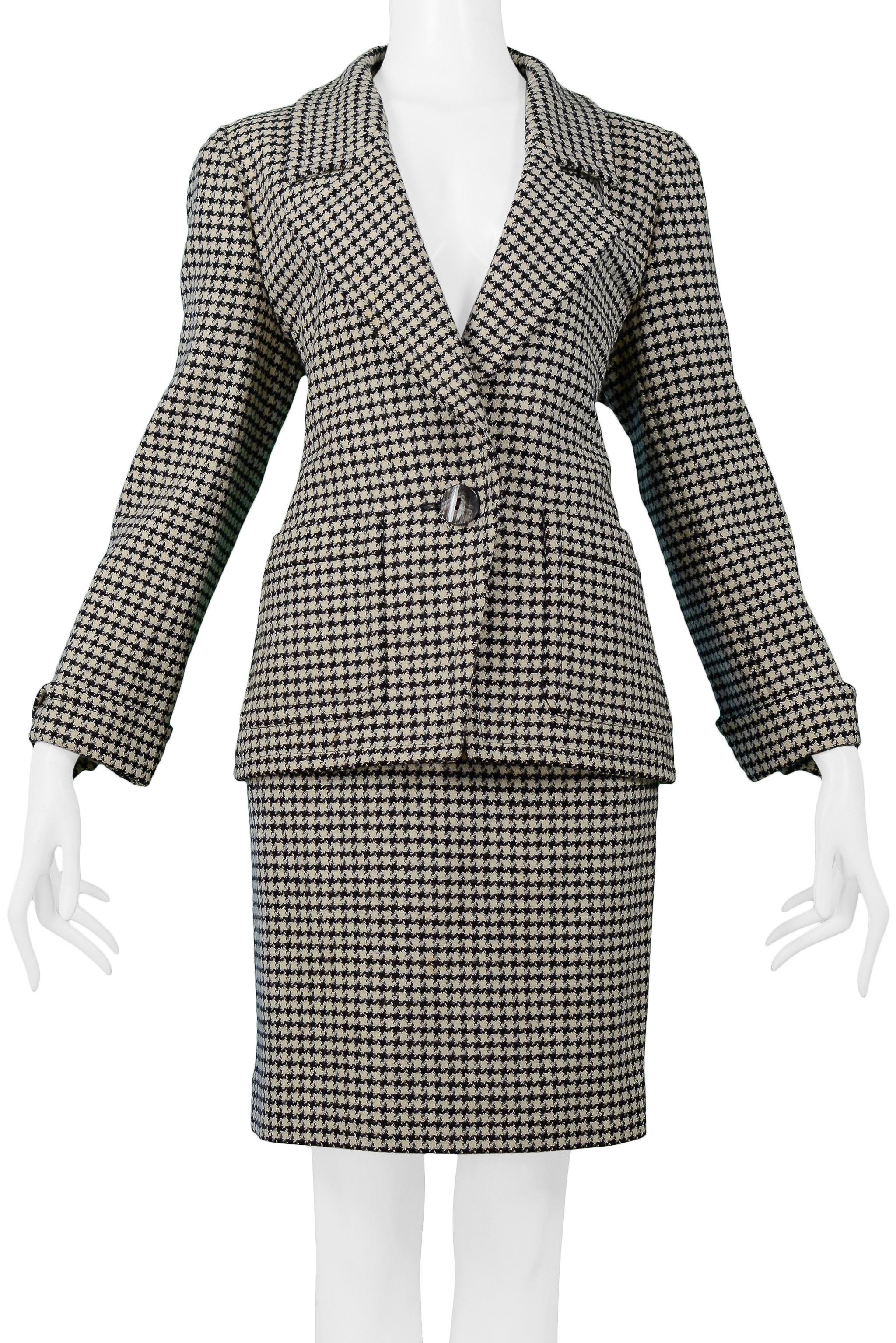 Resurrection Vintage is excited to offer a vintage black, grey, and off-white Yves Saint Laurent wool check skirt suit featuring a hip-length jacket with patch pockets, one-button closure, contrasting shell buttons, folding cuffs with buttons, and