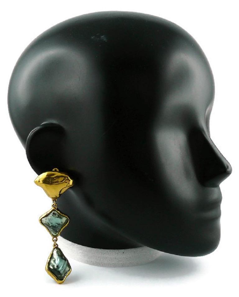 YVES SAINT LAURENT vintage gold toned dangling earrings (clip-on) embellished with irregular shaped blue resin cabochons.

Marked YSL.
Made in France.

Indicative measurements : height approx. 8.6 cm (3.39 inches) / max. width approx. 3 cm (1.18