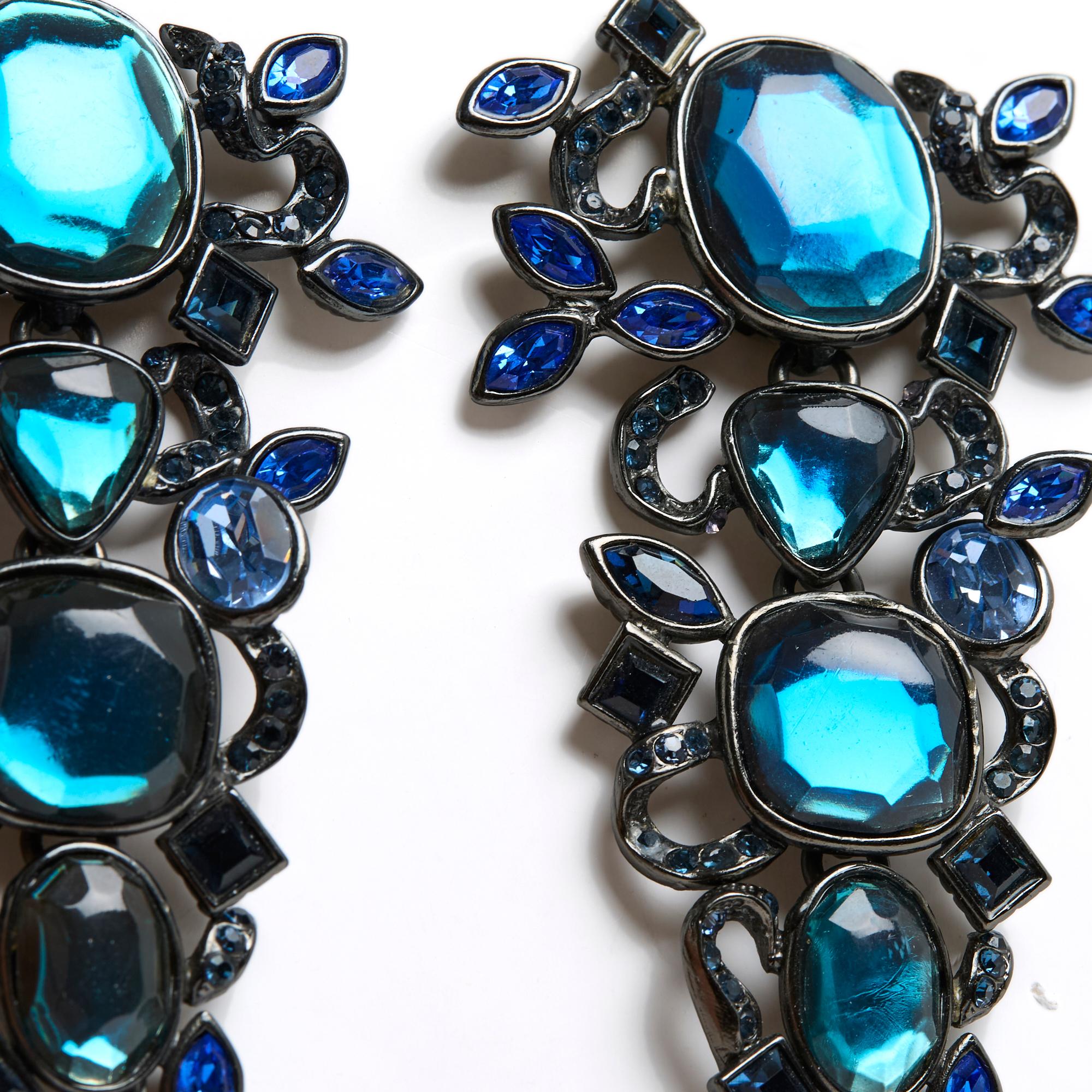 Boucles d'oreilles clips XXL d'Yves Saint Laurent en métal argenté noirci et strass de différentes formes dans différentes nuances de bleu. Largeur 5,7 x hauteur 9,8 cm. Les boucles d'oreilles sont en excellent état, belles portées.