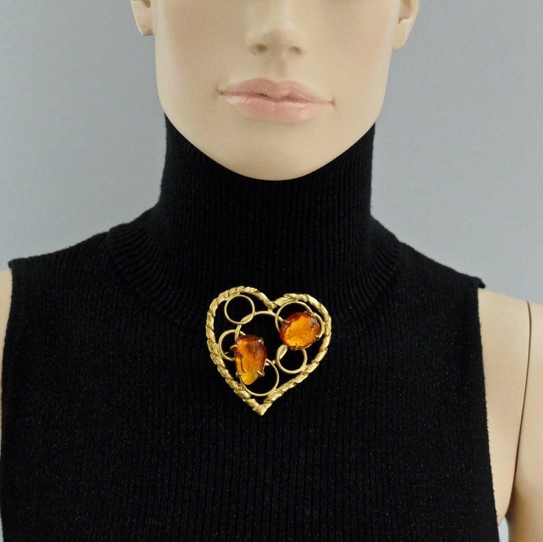 Vintage YVES SAINT LAURENT Ysl by Robert Goossens Openwork Heart Amber Resin Brooch

Measurements:
Height: 2.59 inches (6.6 cm)
Width: 2.51 inches (6.4 cm)

Features:
- 100% Authentic YVES SAINT LAURENT by Robert Goossens.
- Huge openwork heart