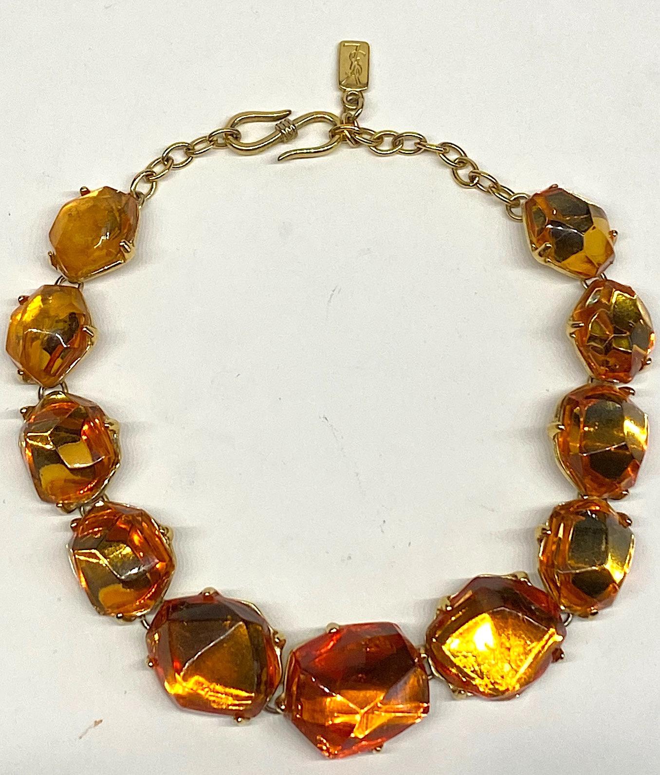 A beautiful 1980s Yves Saint Laurent necklace by famous French designer Robert Goosens. The necklace is comprised of 11 poured and faceted golden honey amber color resin stones. The stones are mounted into gold plate settings and linked together.