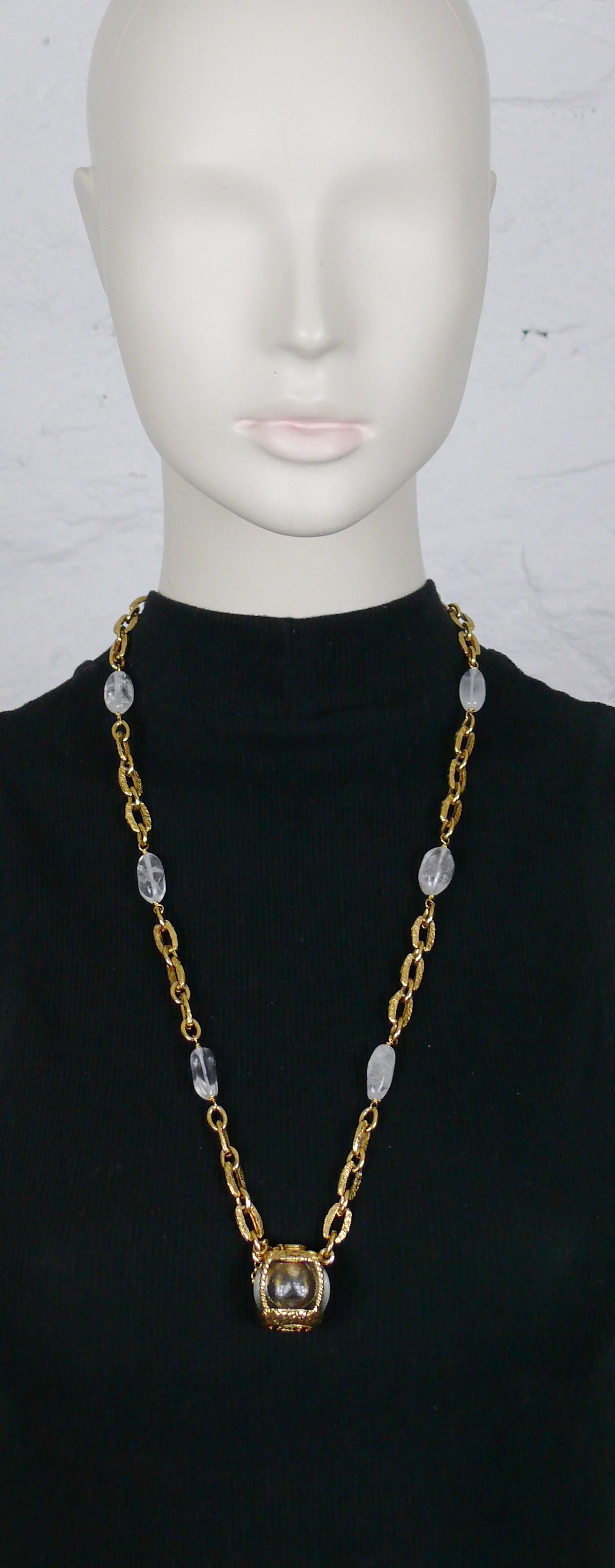 Rare collier vintage YVES SAINT LAURENT créé pour le lancement du parfum CHAMPAGNE par ROBERT GOOSSENS.

Ce collier à maillons texturés est agrémenté de perles en cristal de roche et d'un pendentif miniature en forme de bouteille CHAMPAGNE dans un