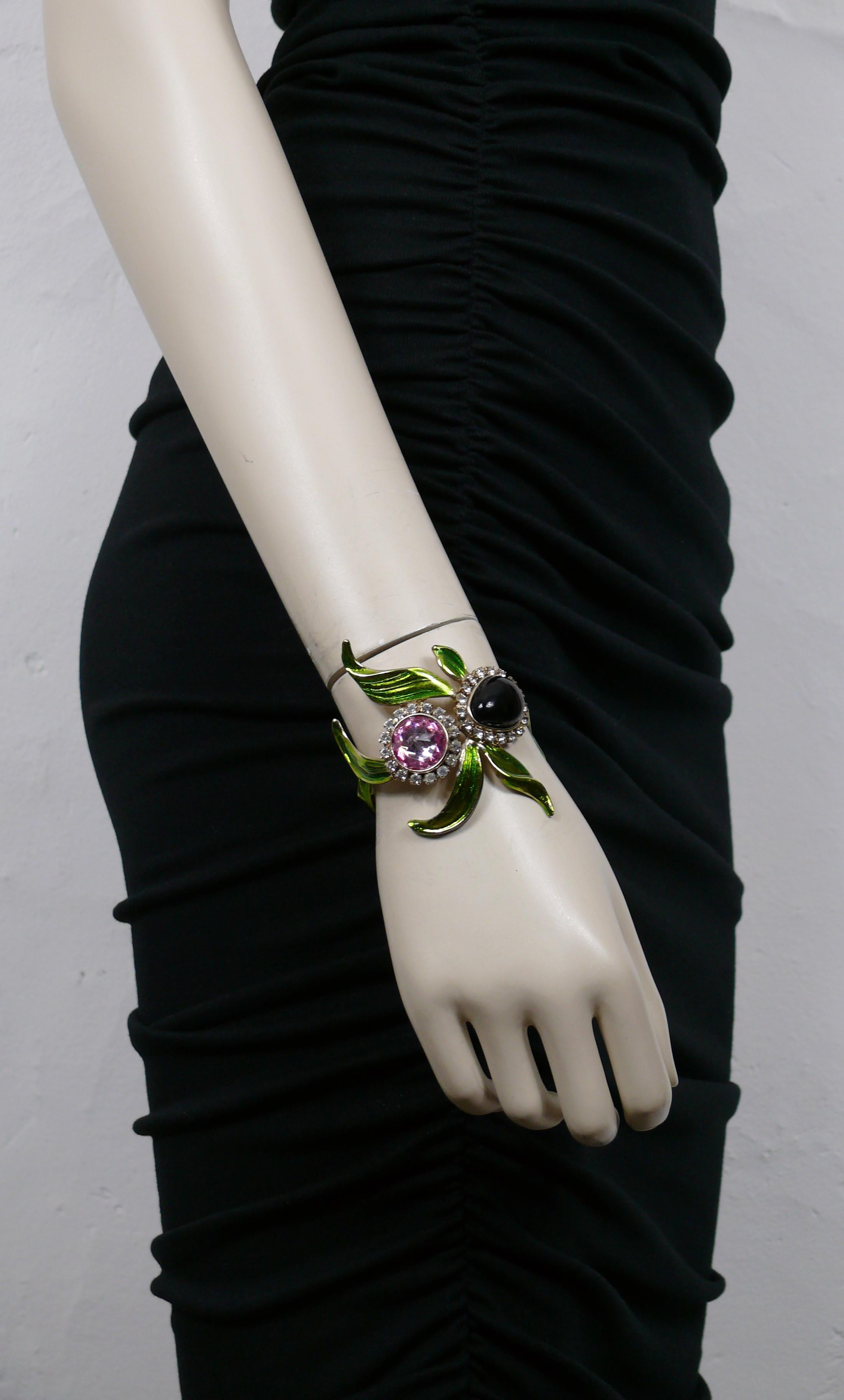 Paire de bracelets manchettes orchidée Yves SAINT LAURENT by TOM FORD, ornés d'un cabochon en verre violet foncé, de cristaux roses et transparents, de feuilles en émail vert dans une monture en or léger.

YVES SAINT LAURENT Printemps-Été 2004 