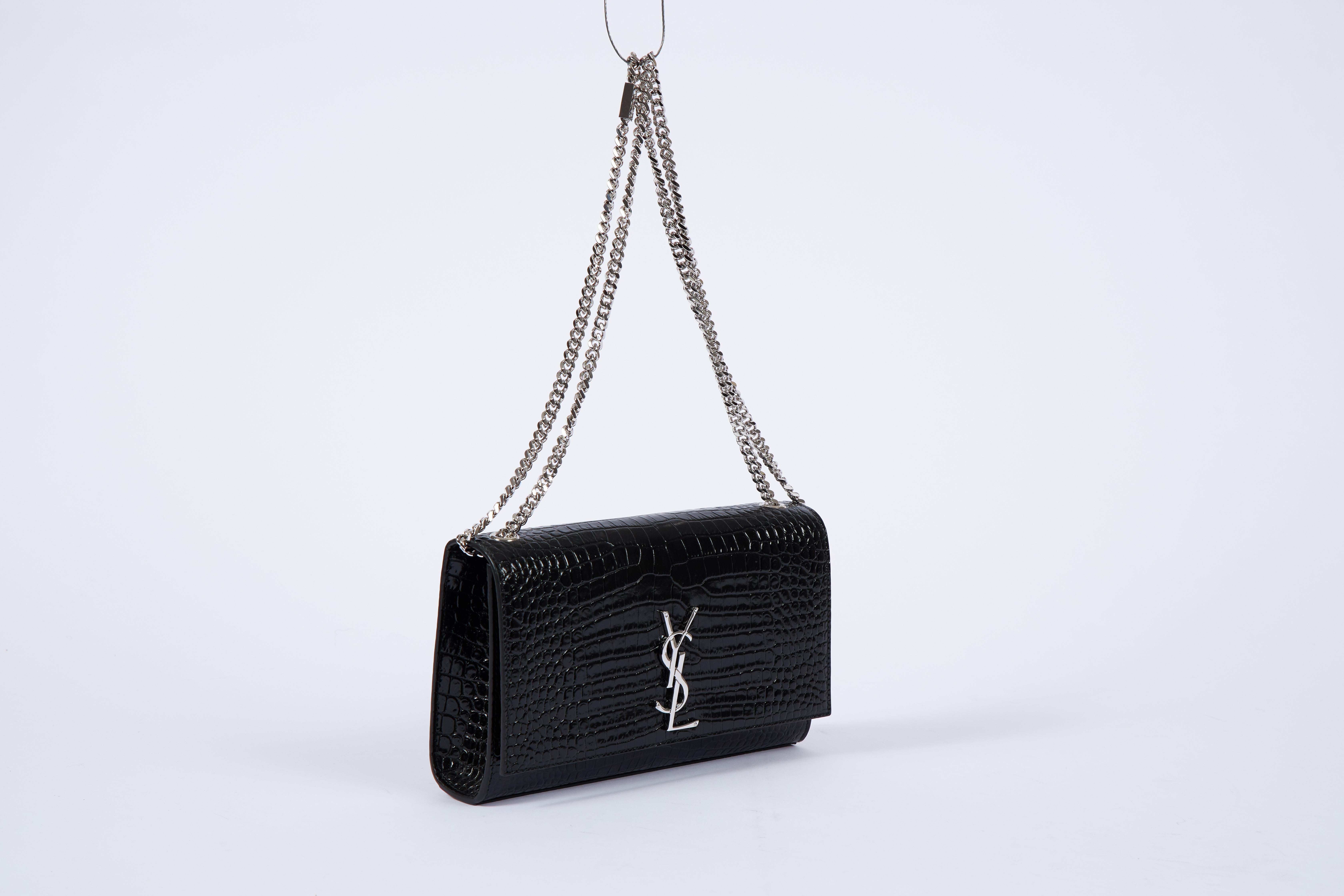 YSL Yves Saint Laurent black patent crocodile embossed handbag with silver tone hardware. Can be worn shoulder length or cross body. Comes with booklet and original dust cover.
