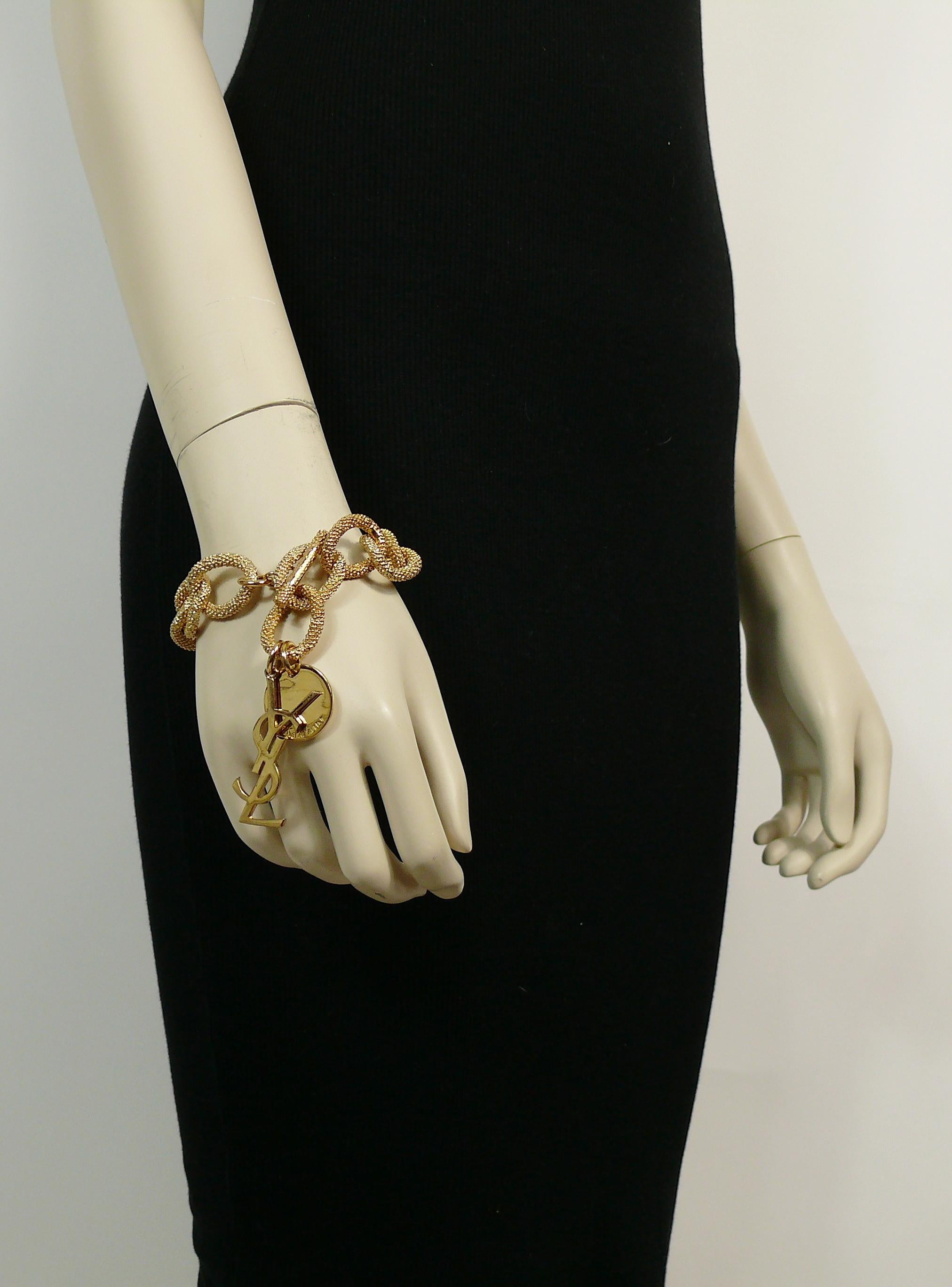 YVES SAINT LAURENT gold toned chain bracelet featuring large textured oval links, YSL logo and coin charm embossed YVES SAINT LAURENT.

T-bar closure.
Adjustable length.

Embossed YVES SAINT LAURENT on the T-bar and coin charm.

Indicative