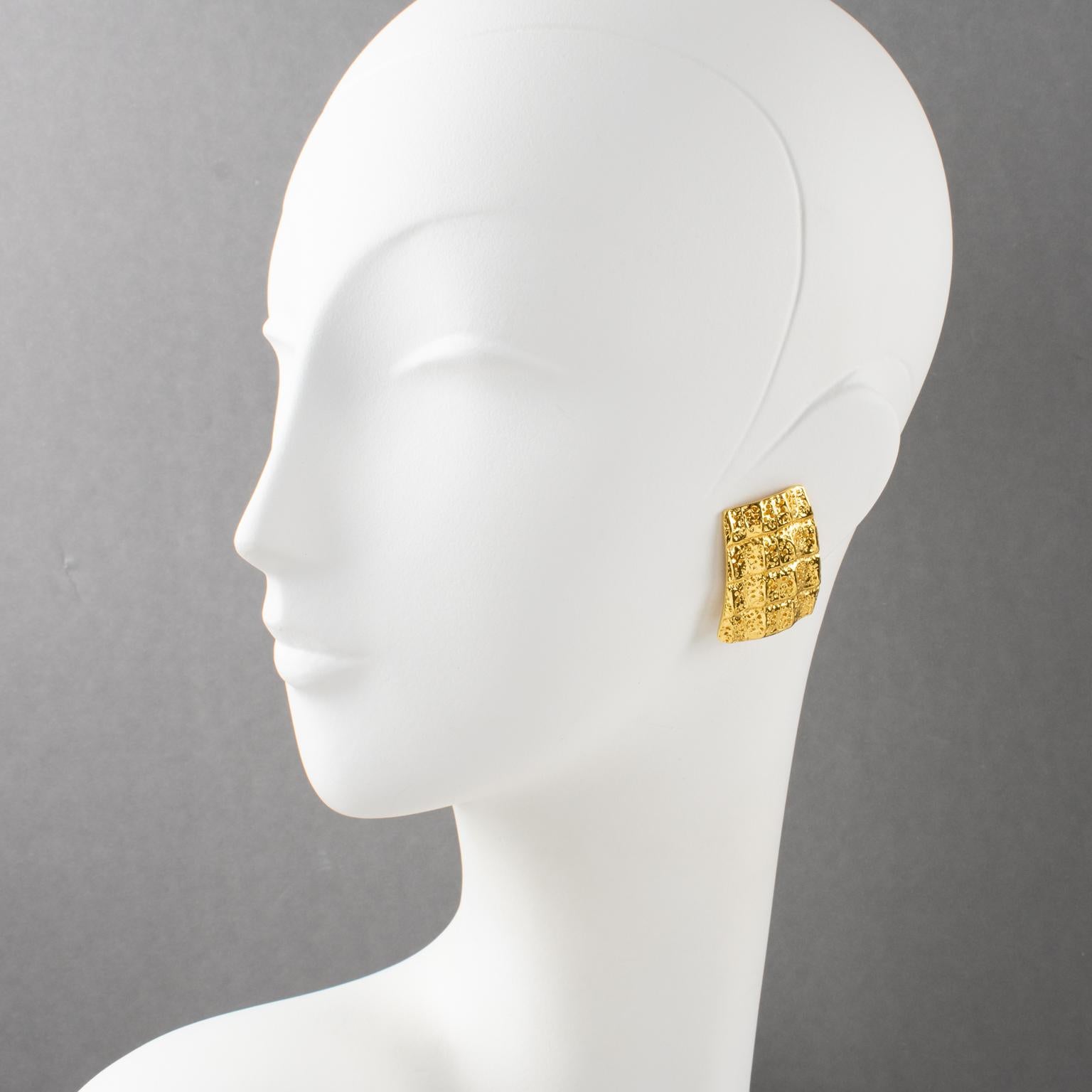 Yves Saint Laurent YSL Paris designed these elegant clip-on earrings in the 1980s. They feature a dimensional geometric shape, gilt metal textured with a crocodile embossed pattern, and a clasp signed with the 