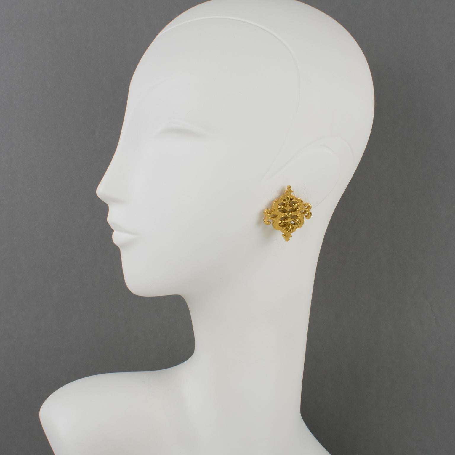 These lovely Yves Saint Laurent Paris stud clip-on earrings feature a square shape with gilded metal, all textured and carved in a baroque see-through design. The earrings are signed at the back with the YSL pierced logo on the fastenings and