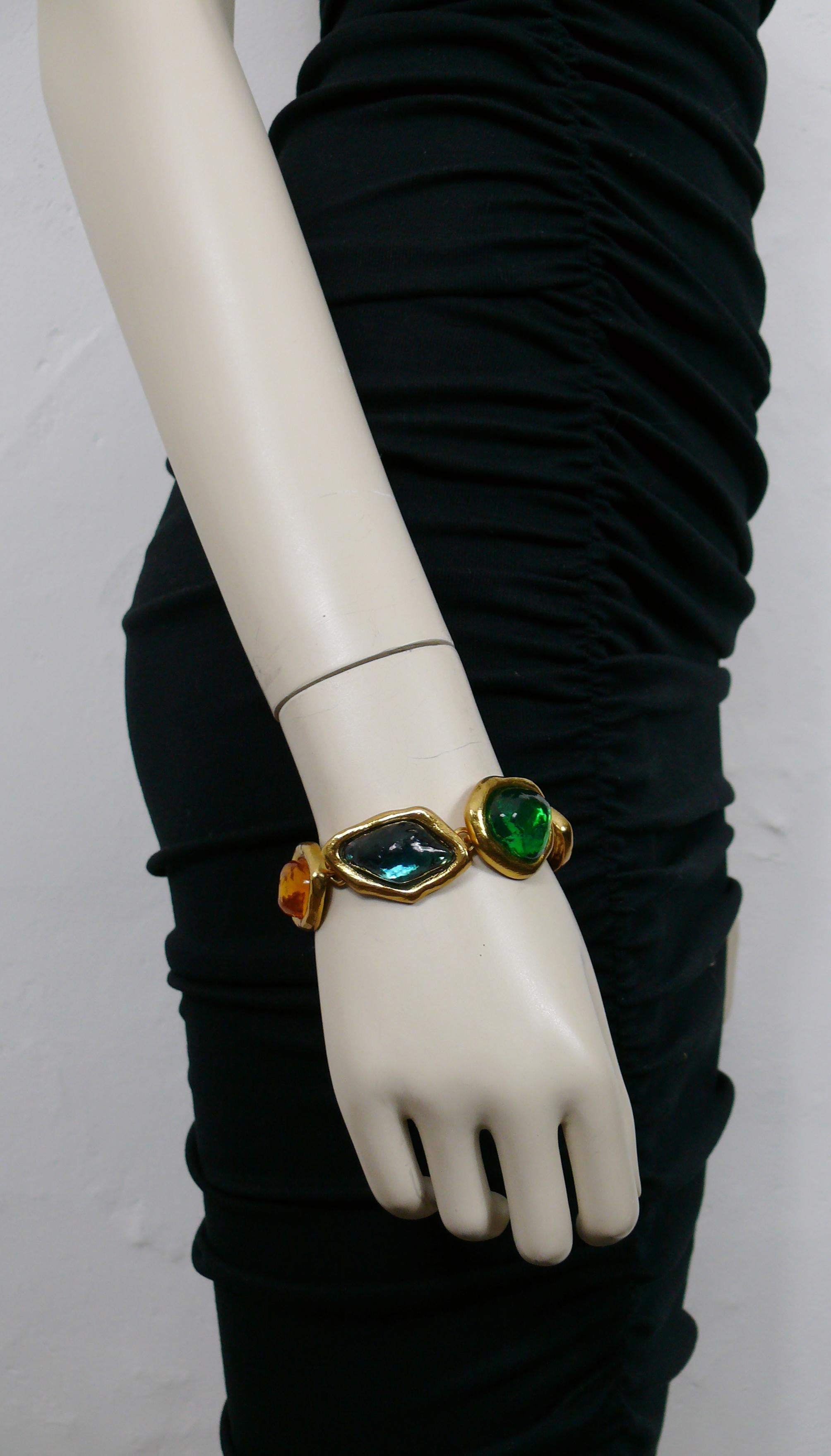 YVES SAINT LAURENT vintage gold toned irregular shaped link bracelet embellished with three dimensional multicolored resin cabochons.

Created by French parurier ROBERT GOOSSENS for YVES SAINT LAURENT.

Adjustable T bar and toggle closure.

Embossed