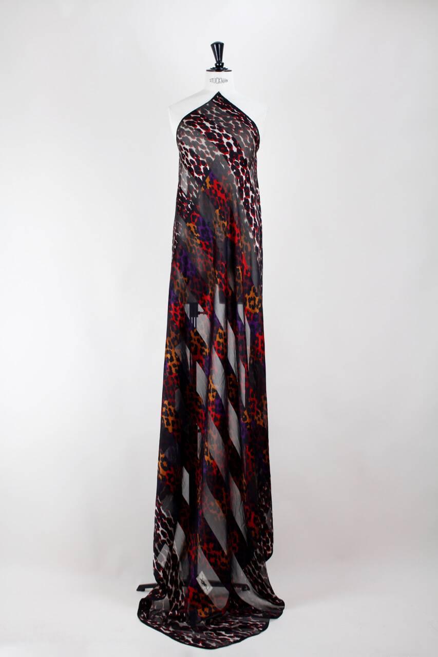 This semi-sheer oversized square Yves Saint Laurent silk scarf or wrap from the 1980s features a wonderful leopard print on alternating stripes of silk crepe and silk chiffon. The center of the scarf comes in shades of red, burnt orange and dark