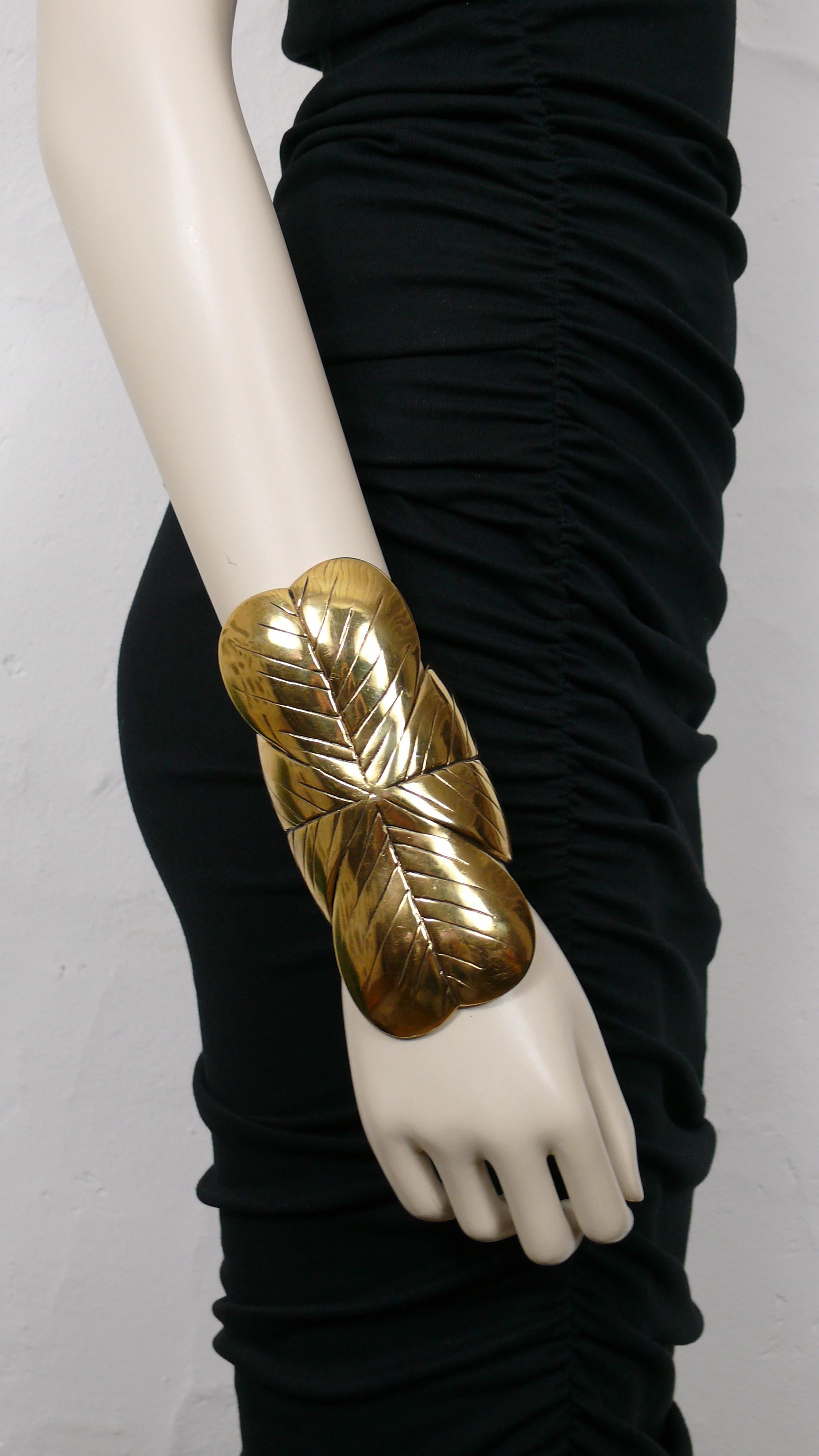 YVES SAINT LAURENT massive gold tone cuff bracelet featuring a four leaf clover.

Embossed YVES SAINT LAURENT.

Indicative measurements : inner measurements approx. 5.1 cm (2 inches) x 4 cm (1.57 inches) / max. length approx. 14 cm (5.51 inches) /