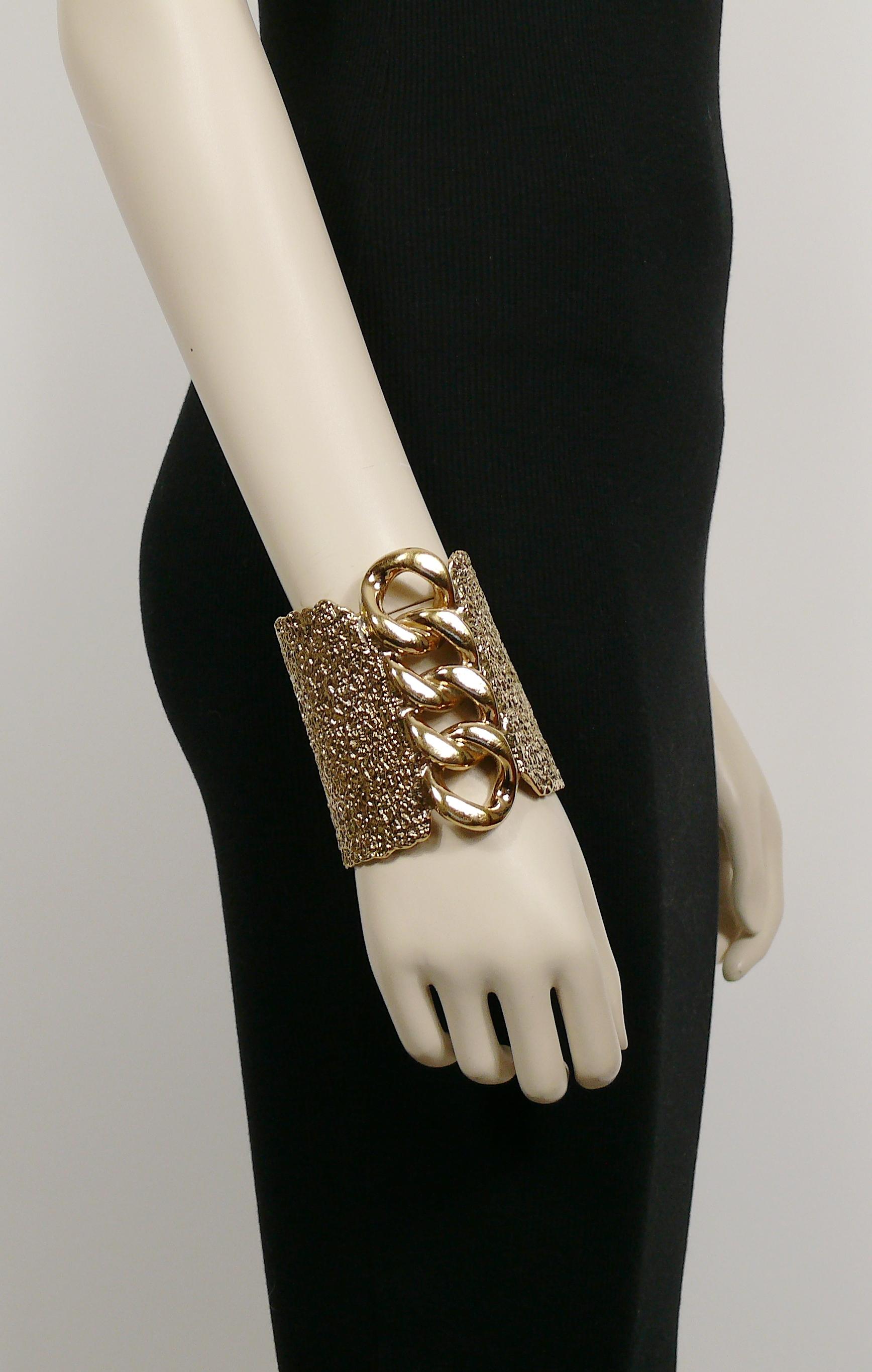 YVES SAINT LAURENT massive textured gold tone cuff bracelet featuring a large rigid chain design on the front.

Embossed YVES SAINT LAURENT.

Indicative measurements : min. inner width approx. 6 cm (2.36 inches) / max. inner width approx. 6.9 cm