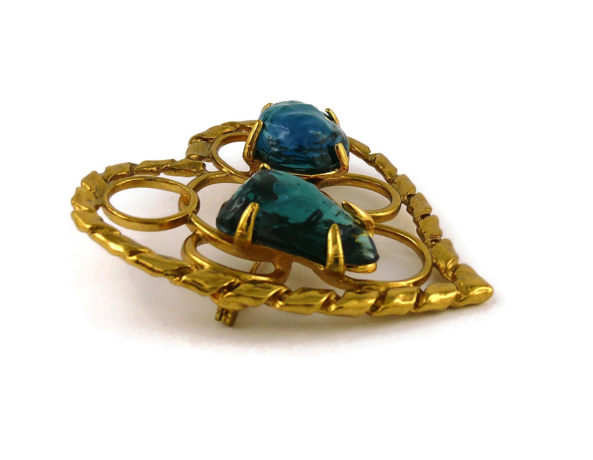 YVES SAINT LAURENT vintage large openwork gold toned heart brooch embellished with poured resin in blue colour.

Embossed YSL Made in France.

Indicative measurements : max. height approx. 6.2 cm (2.44 inches) / max. width approx. 6.4 cm (2.52