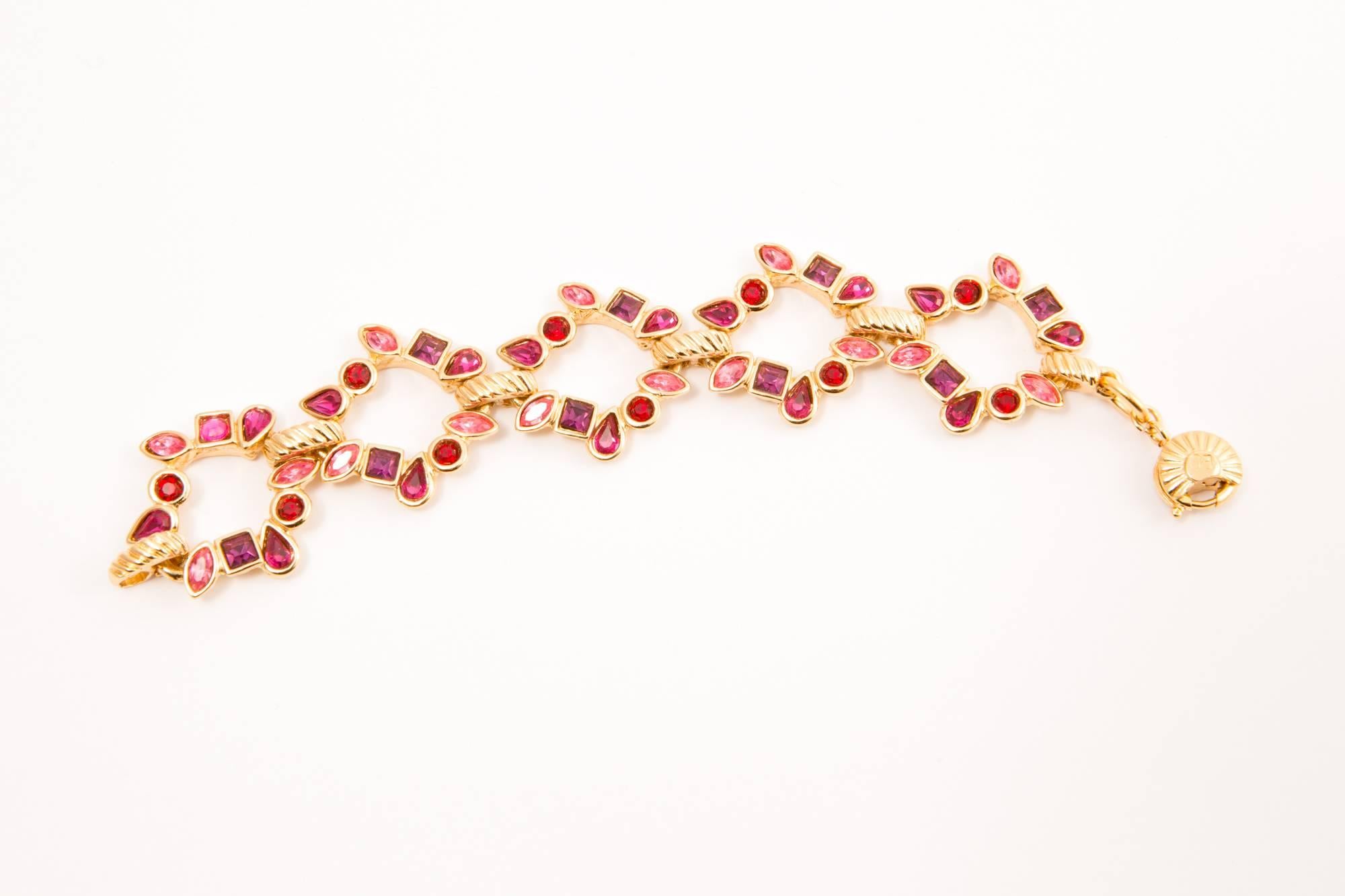 Yves Saint Laurent red, pink glass strass bracelet featuring gold tone articulated parts and a spring-ring fastening with logo pitted on.
In excellent vintage condition. Made in France.
Length open 7,4in. (19cm)
Width 1.18in. (3cm) 
We guarantee you