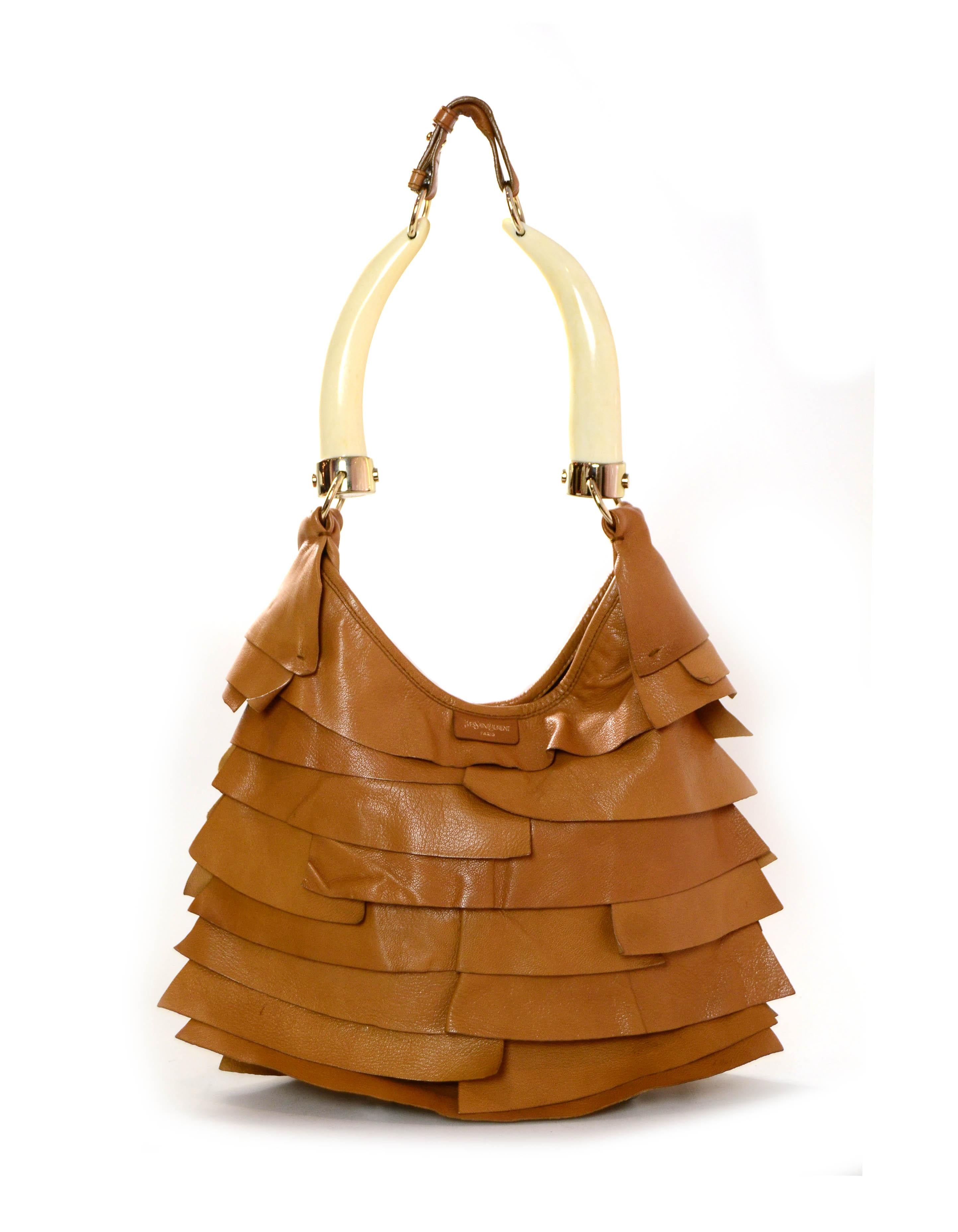 Yves Saint Laurent St. Tropez Mombasa Ruffled Bag w/Horn Handles

Made In: Paris
Color: Tan
Hardware: Goldtone
Materials: Leather
Lining: Suede
Closure/Opening: Snap
Interior Pockets: Side zipper
Exterior Condition: Good - small mark at front,